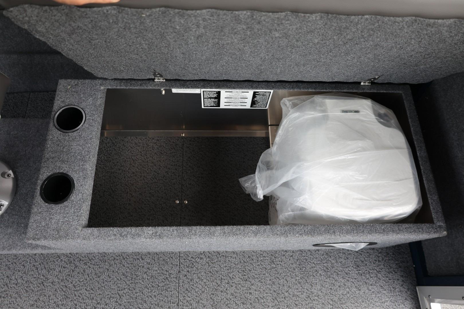 Storage compartment in 2026 Thunder Jet 24 Alexis Pro boat, featuring carpeted interior and cup holders.