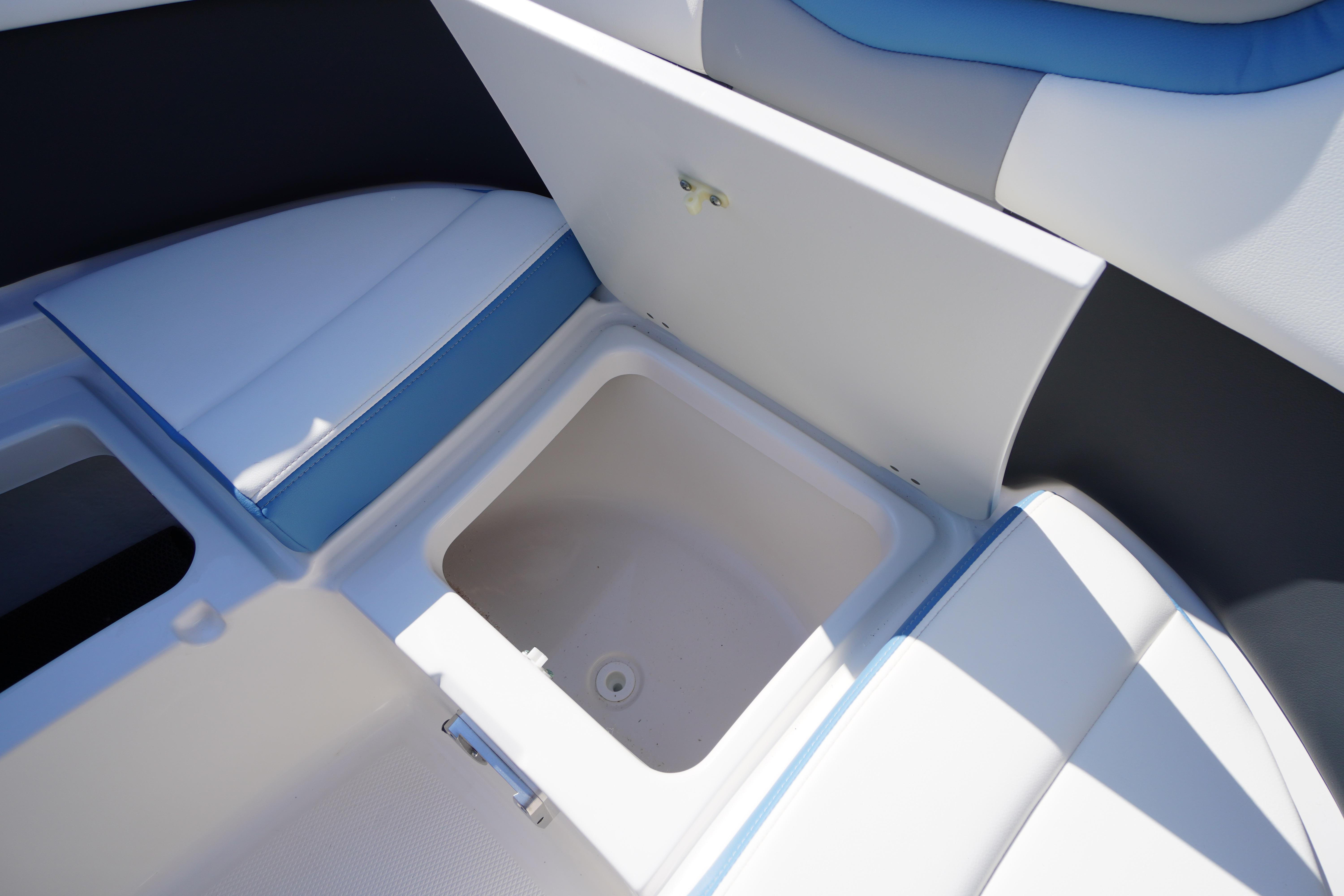 2026 Chaparral 270 OSX boat interior storage compartment with blue and white seating.