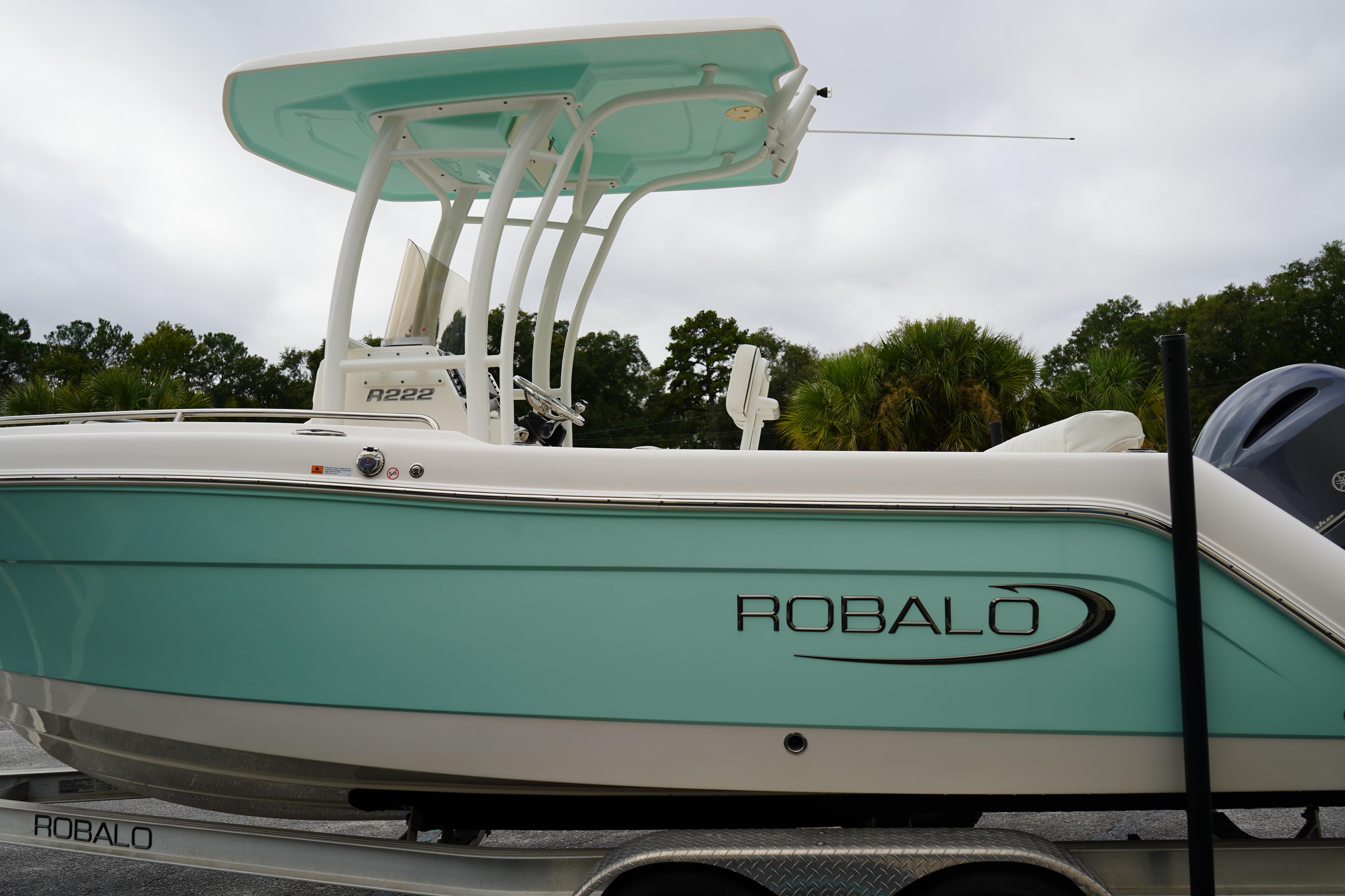 2023 Robalo R222 Center Console boat on trailer, side view, teal and white design.