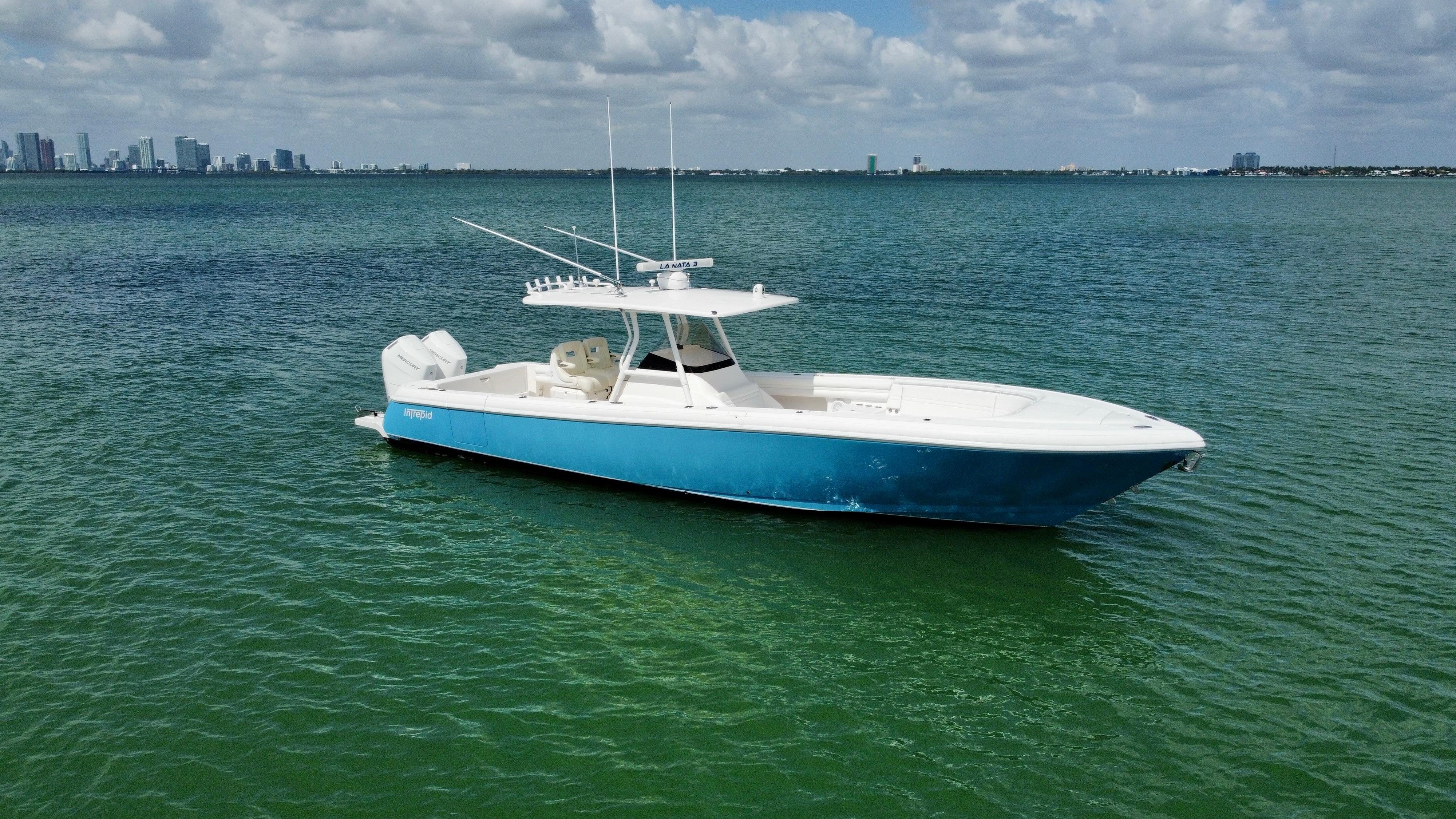 2015 Intrepid 375 Center Console boat on calm green water under cloudy sky.