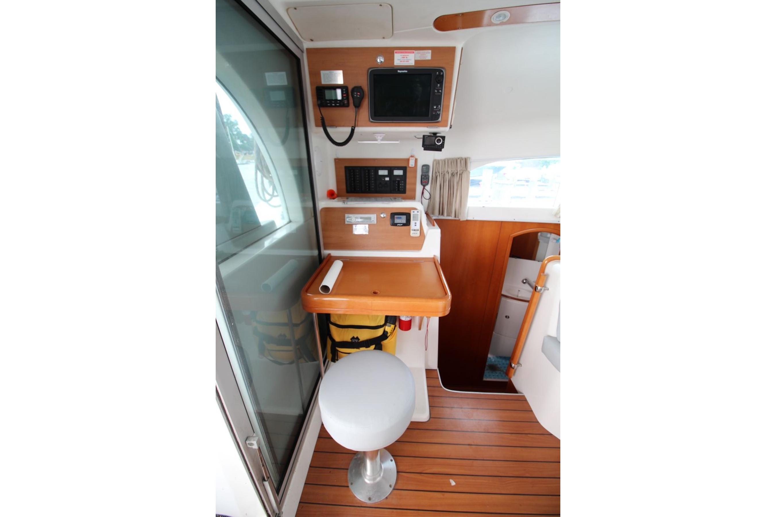 Interior of 2004 Lagoon 380 catamaran with navigation station and wooden flooring.