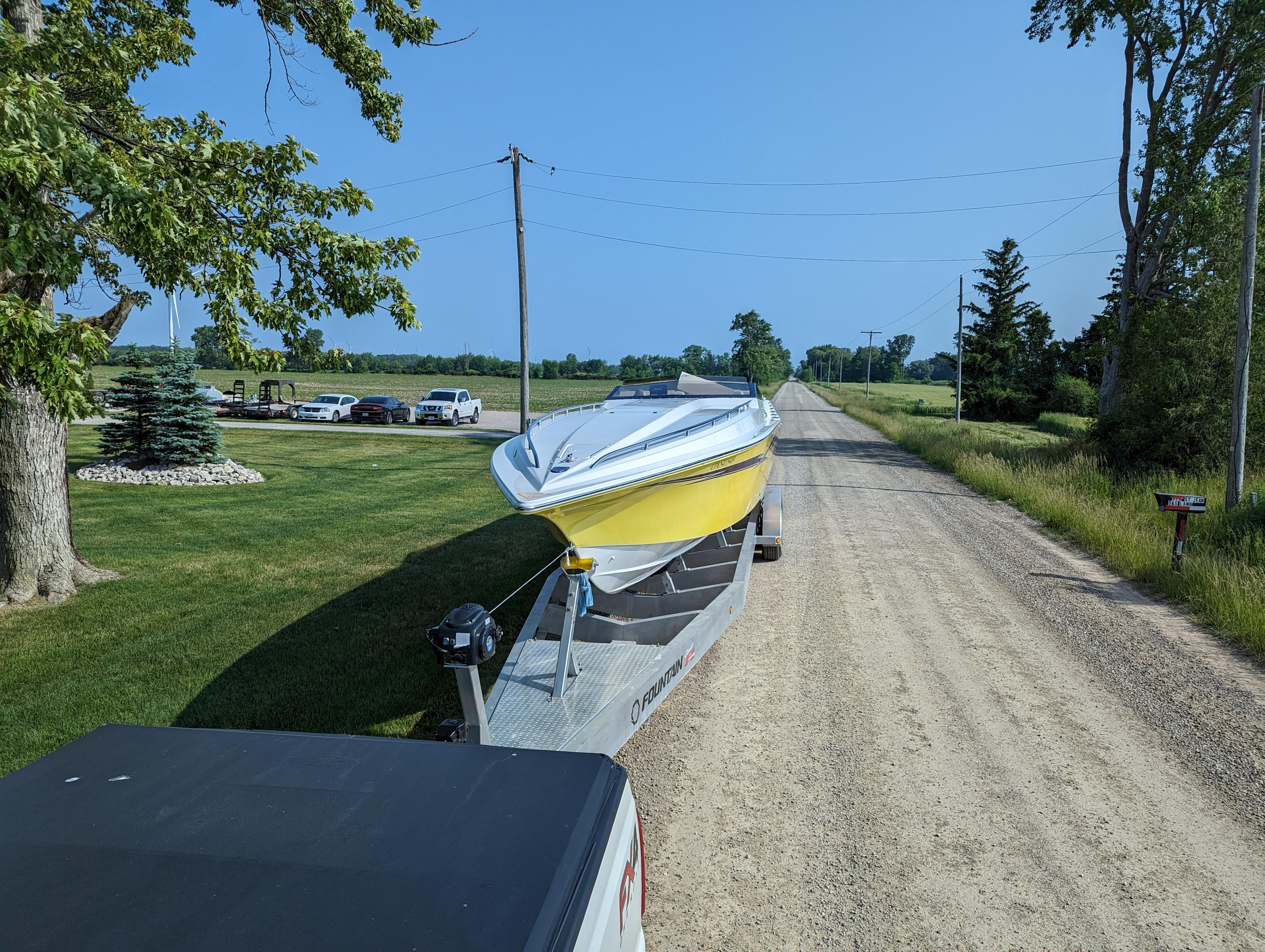 Yellow Fountain 42 boat on trailer, rural road, clear sky, 2006 model.