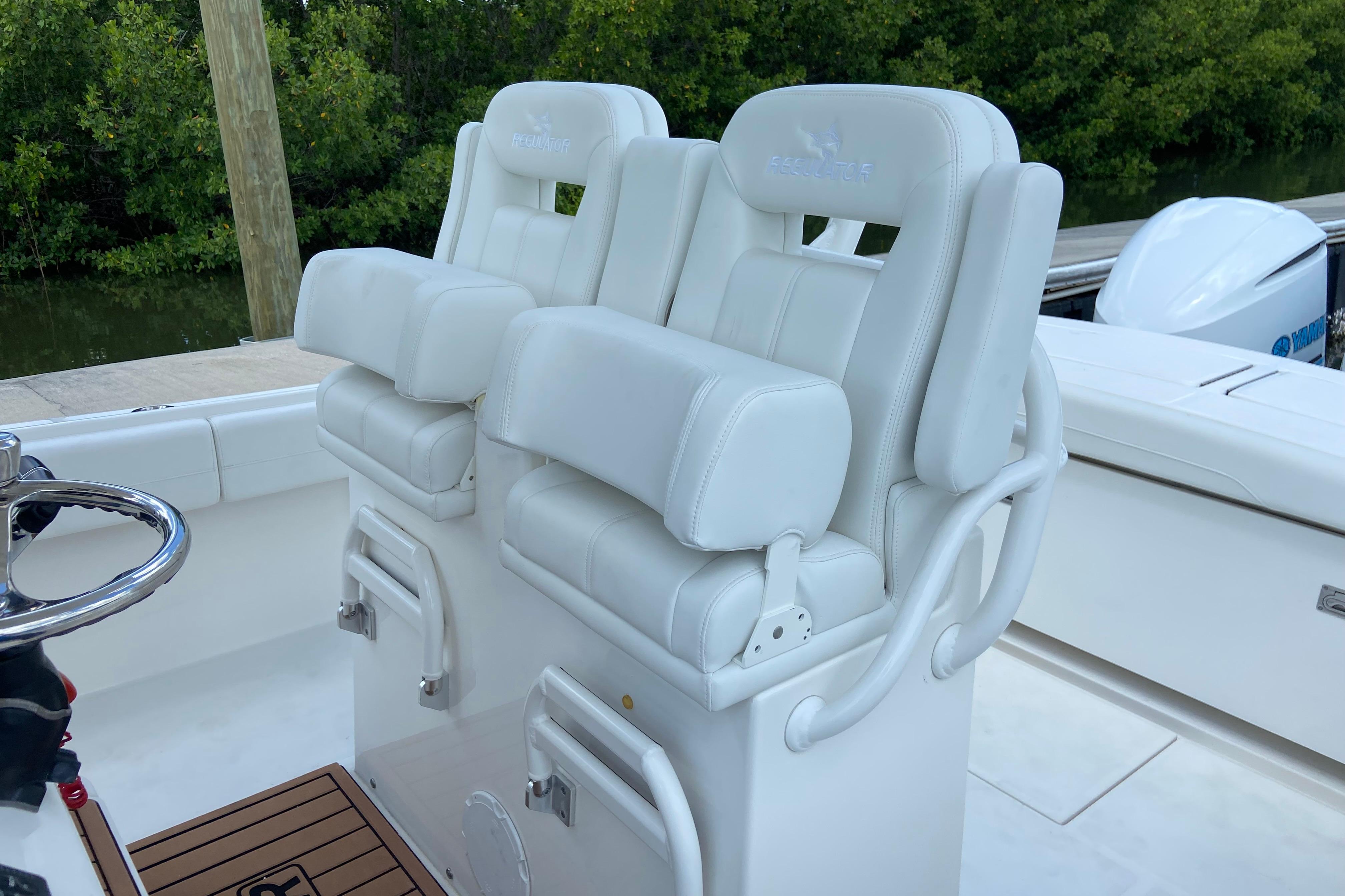 2021 Regulator 28 boat with white cushioned helm seats and steering wheel.
