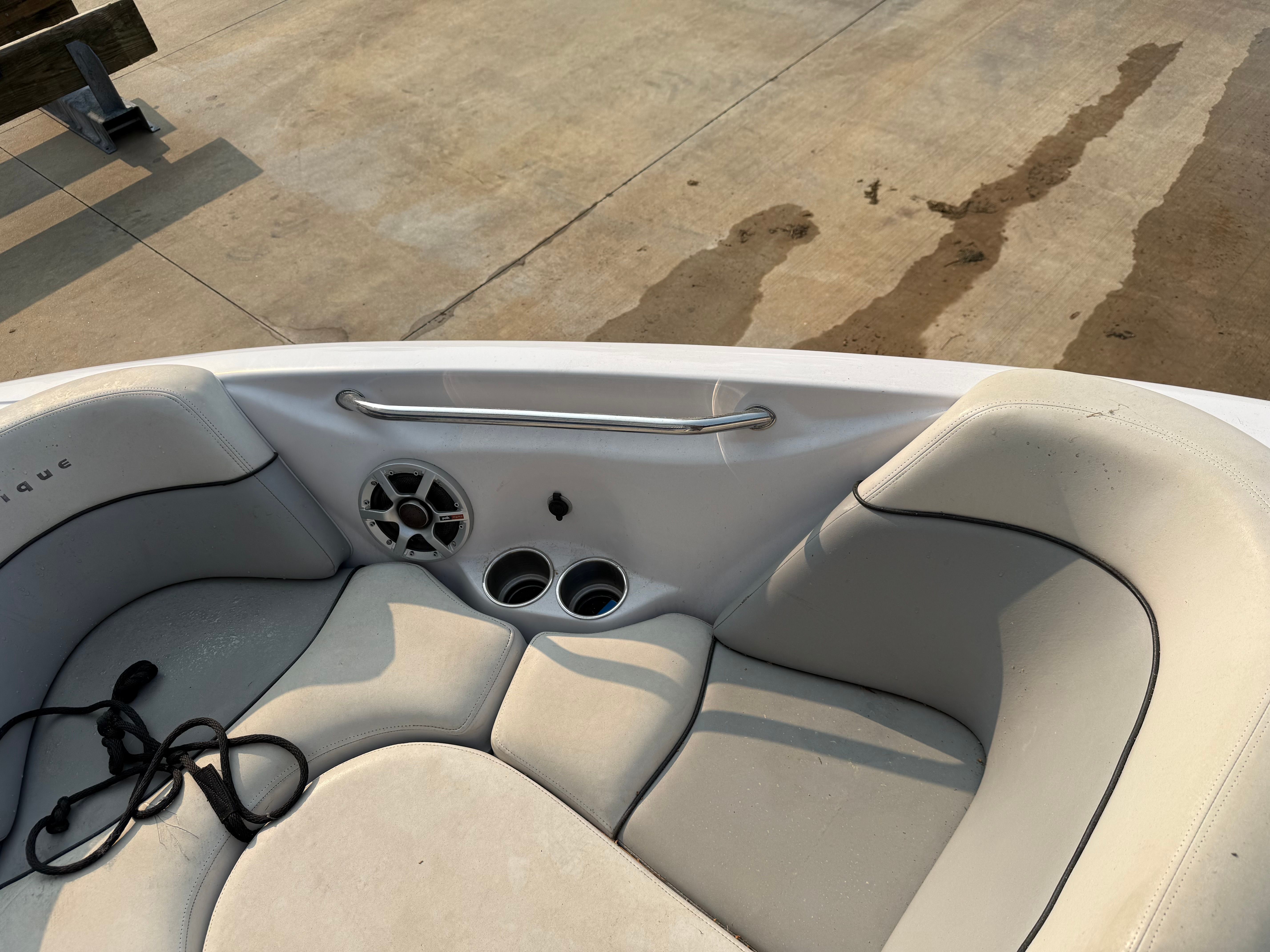 The image shows the bow area of a 2007 Nautique SV 211 with white upholstery and cup holders.