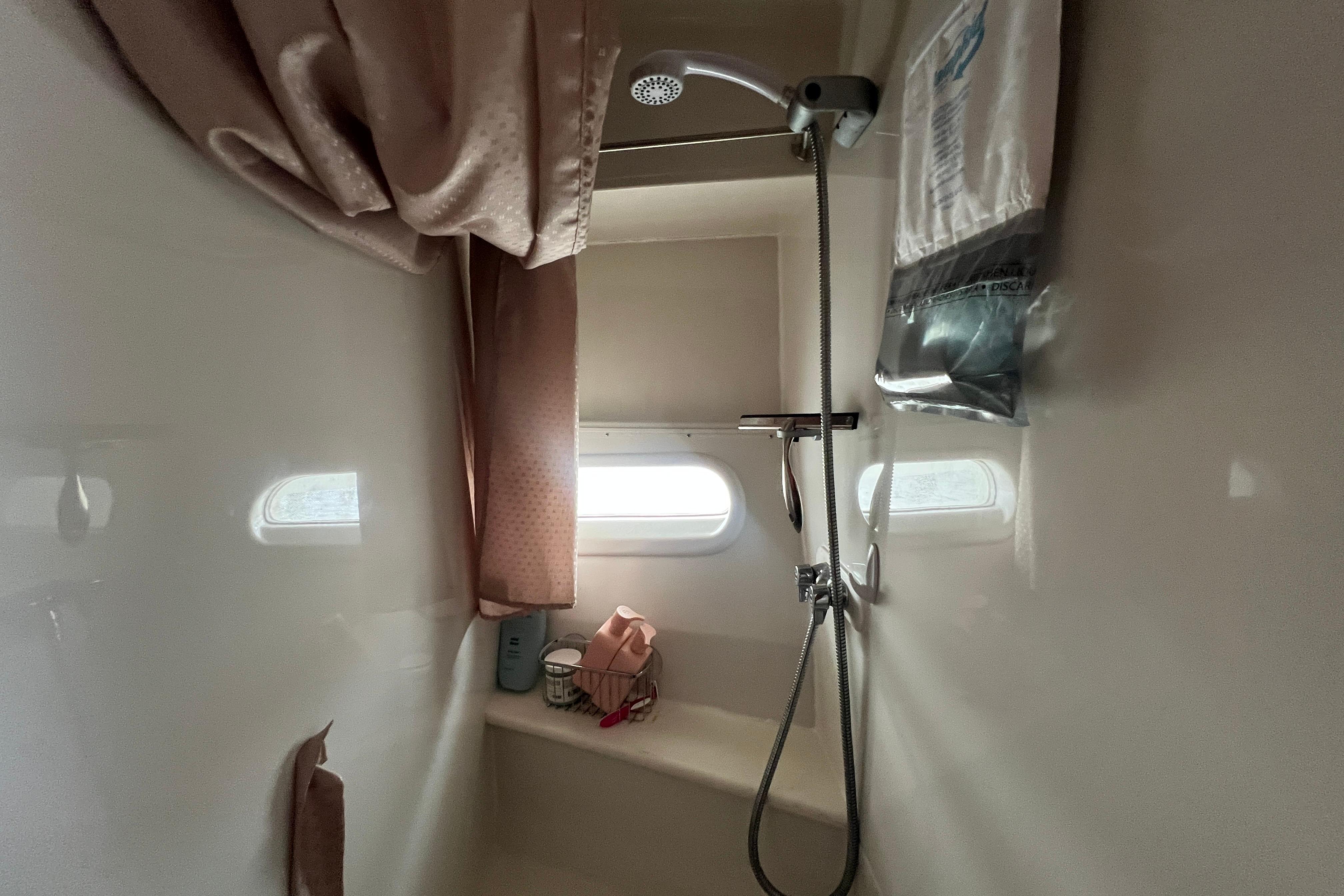 Shower area inside 2006 Carver 43 Motor Yacht with window and curtain.