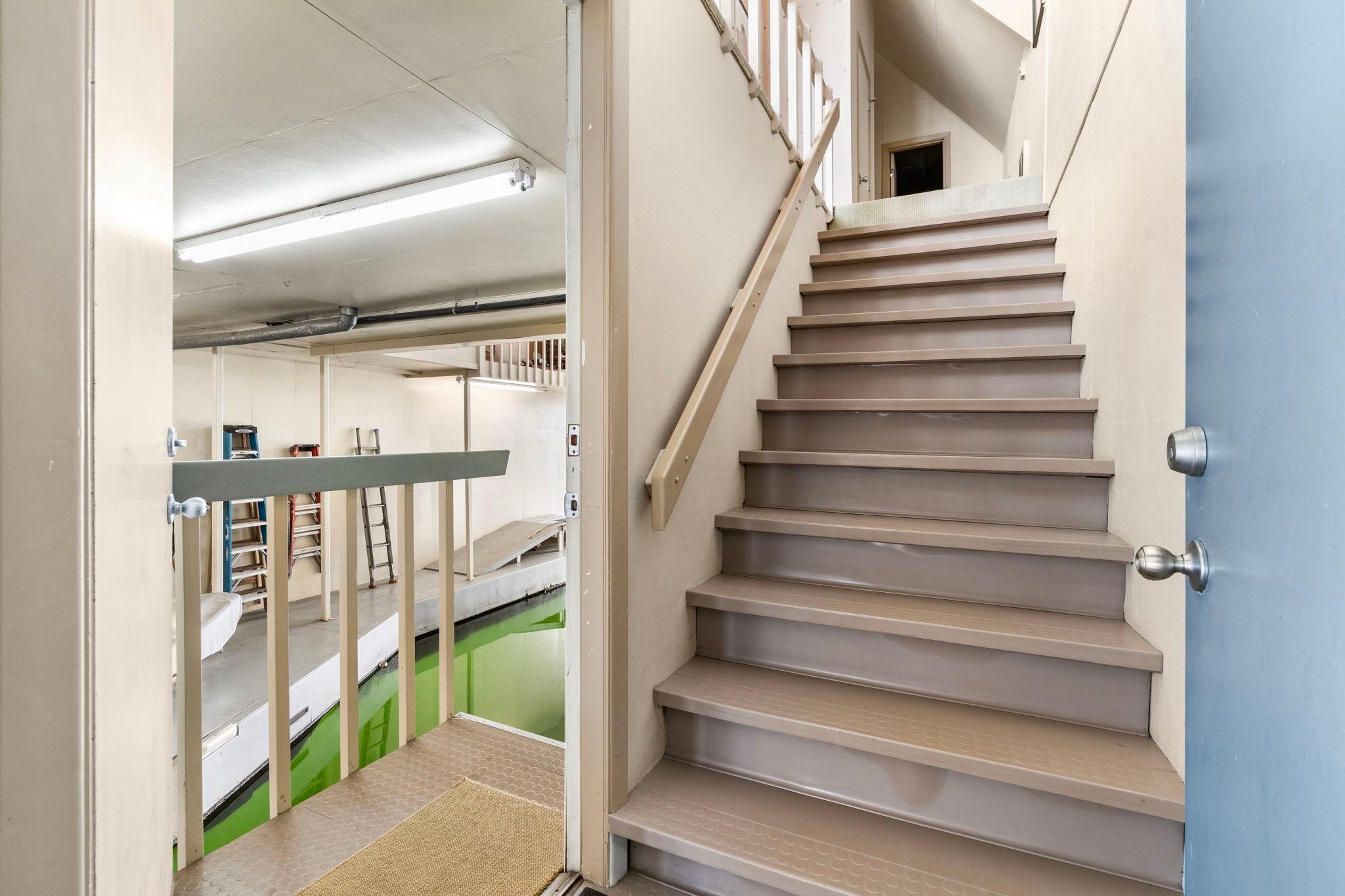 Staircase in a 1976 custom boathouse with indoor waterway and storage area.