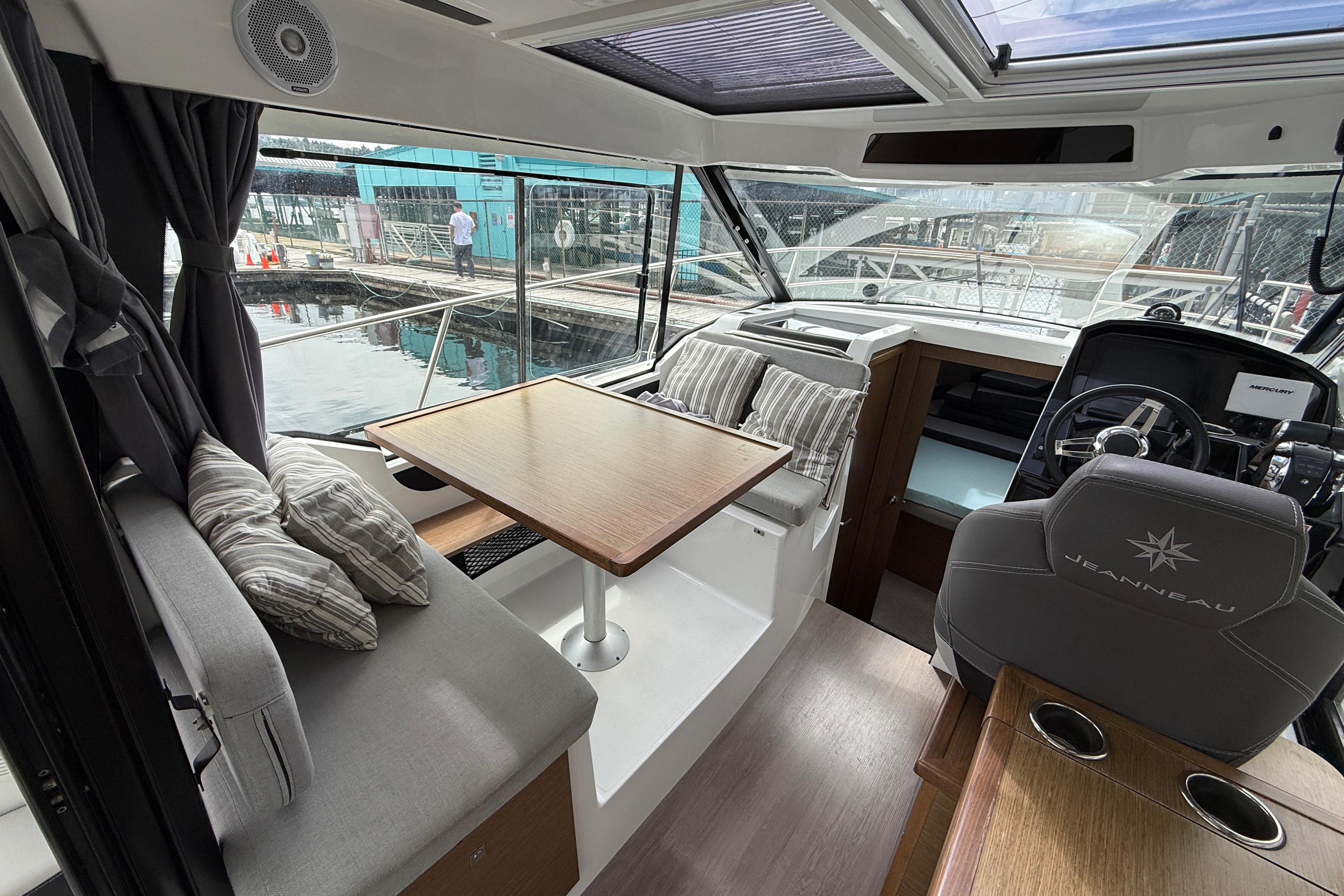 Interior of 2020 Jeanneau NC 895 boat with seating, table, and helm station.