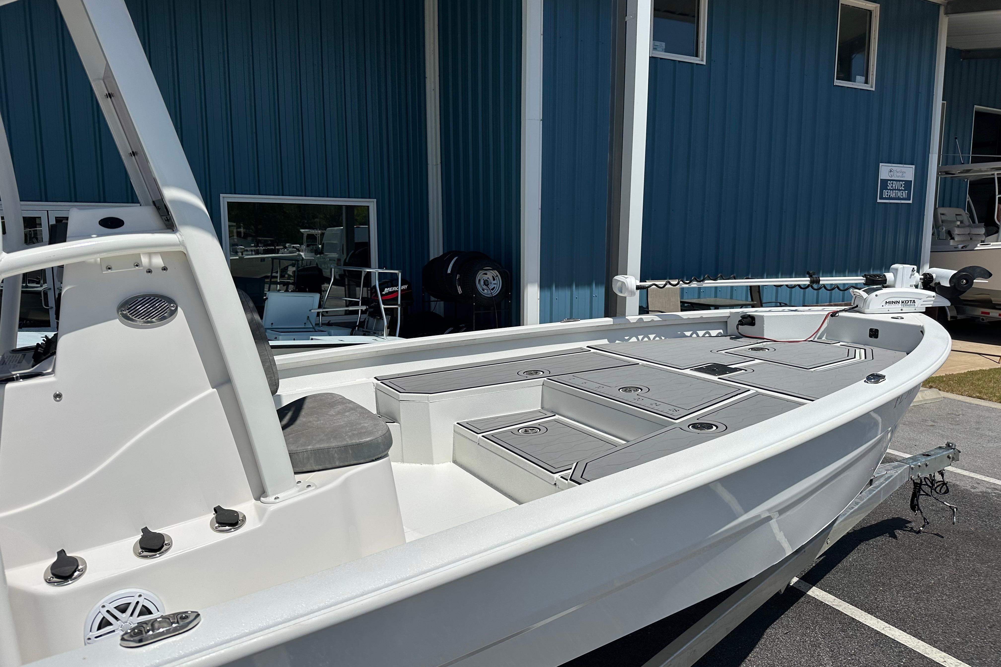 2024 Avid 23 Mag boat with sleek design, docked near blue building.