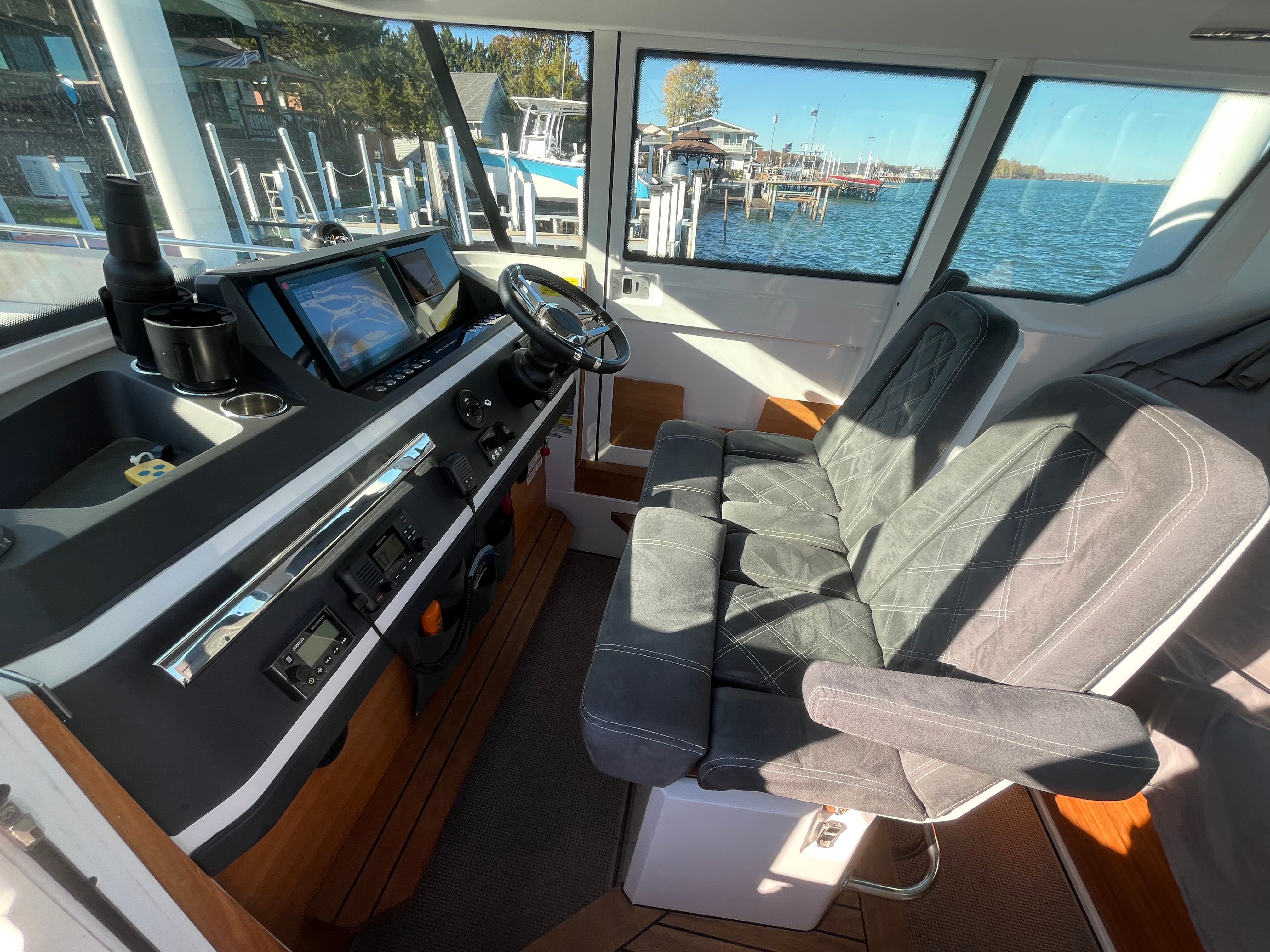 Interior of a 2018 Axopar 28 Cabin with gray seats and a steering console.