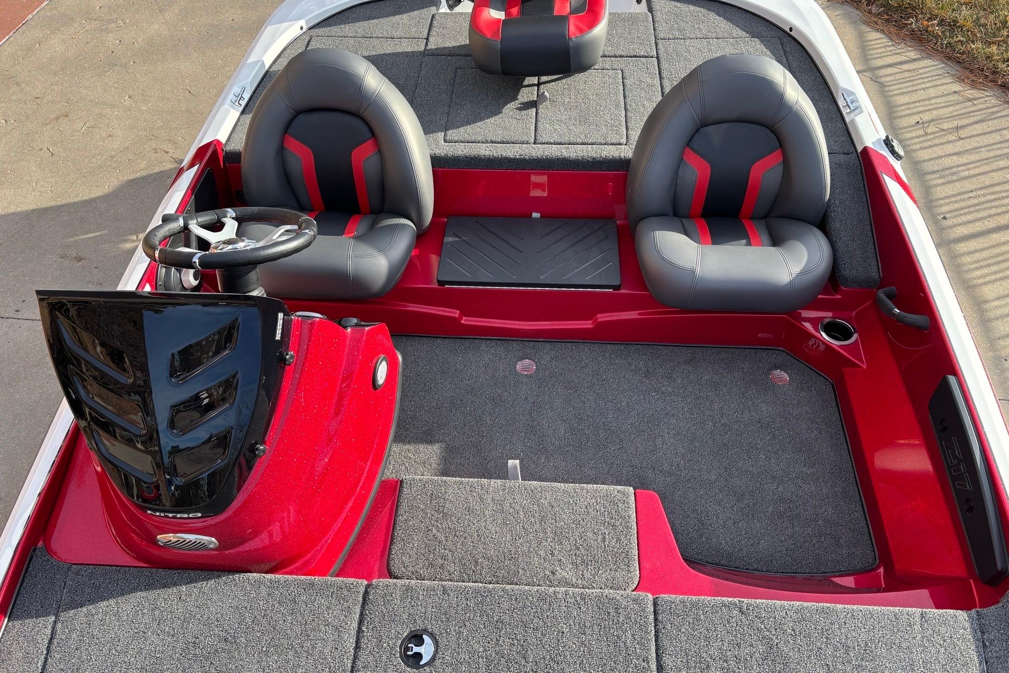 Red and gray interior of a 2026 Nitro Z17 boat with dual seats and steering wheel.