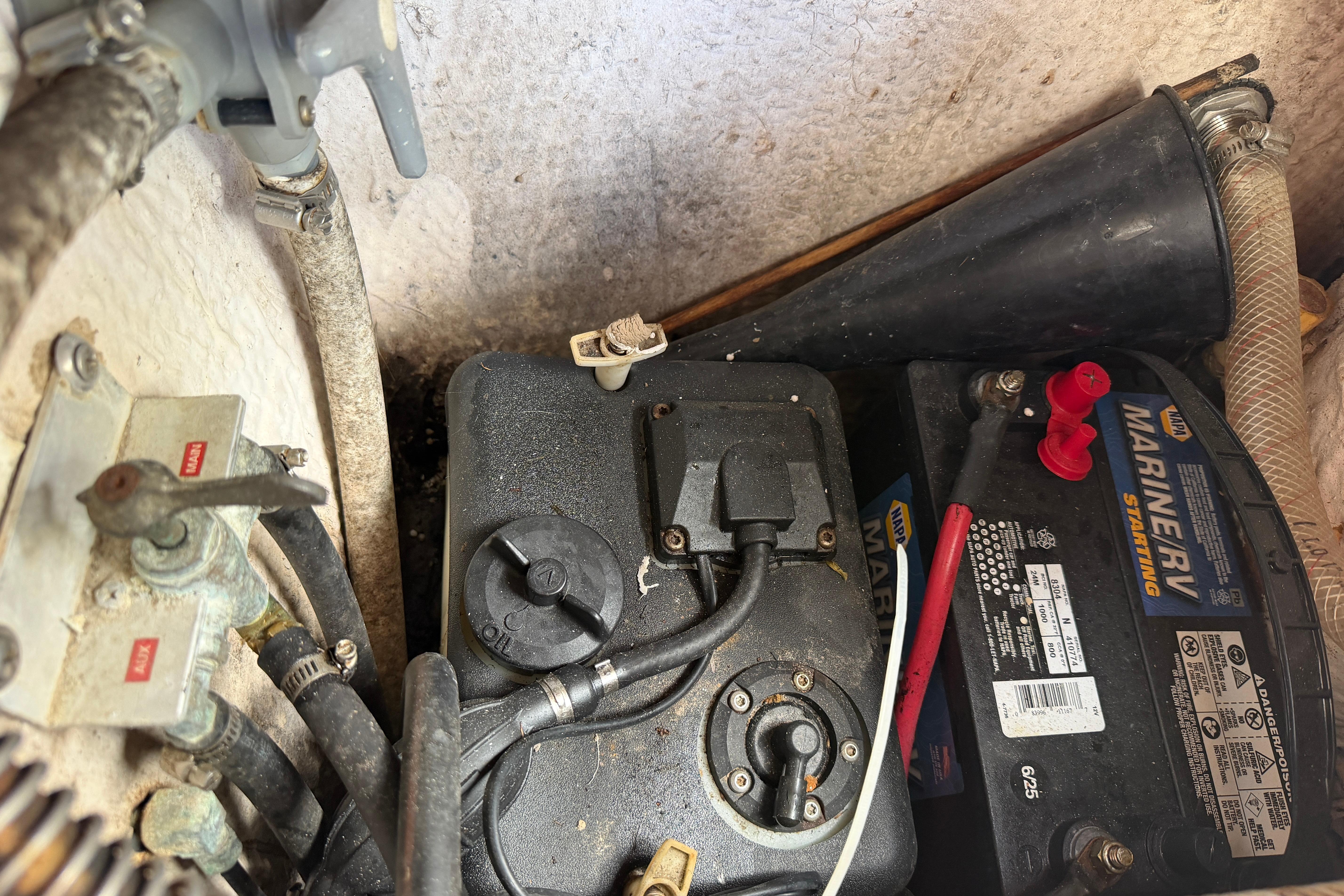 1987 Grady-White Seafarer 226 engine compartment with battery and wiring components.