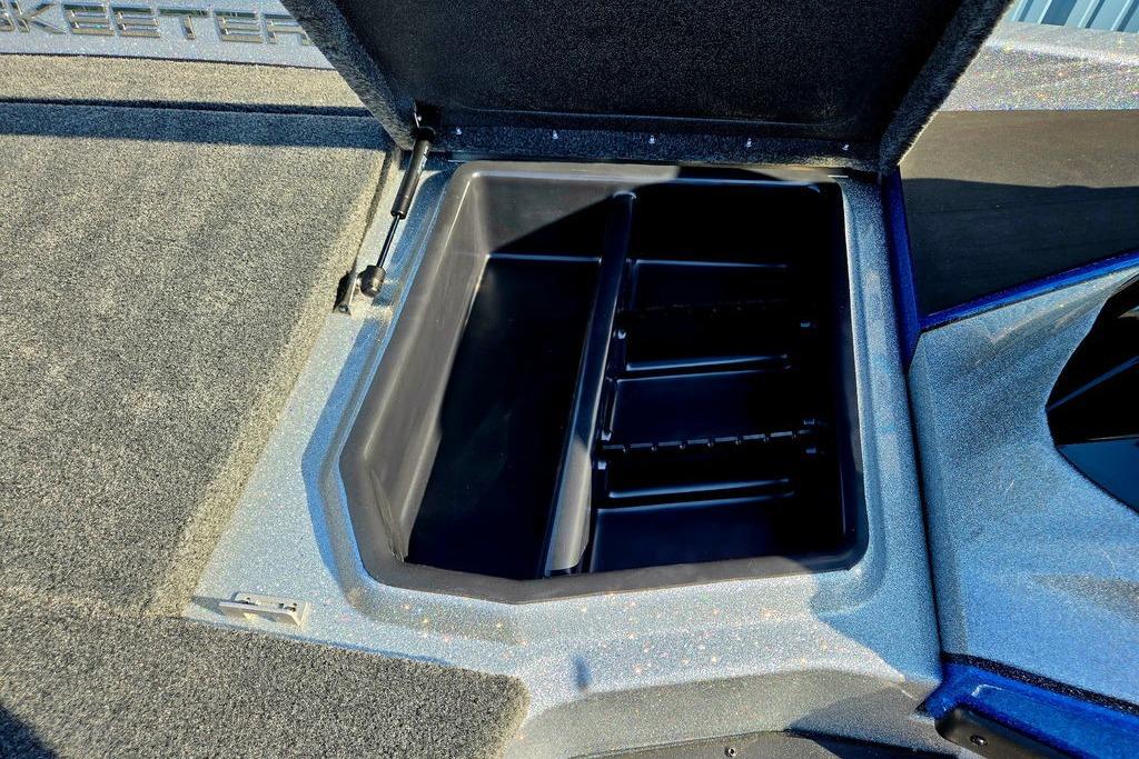 Open storage compartment in 2026 Skeeter ZXE20 boat, featuring carpeted interior and hydraulic lift.