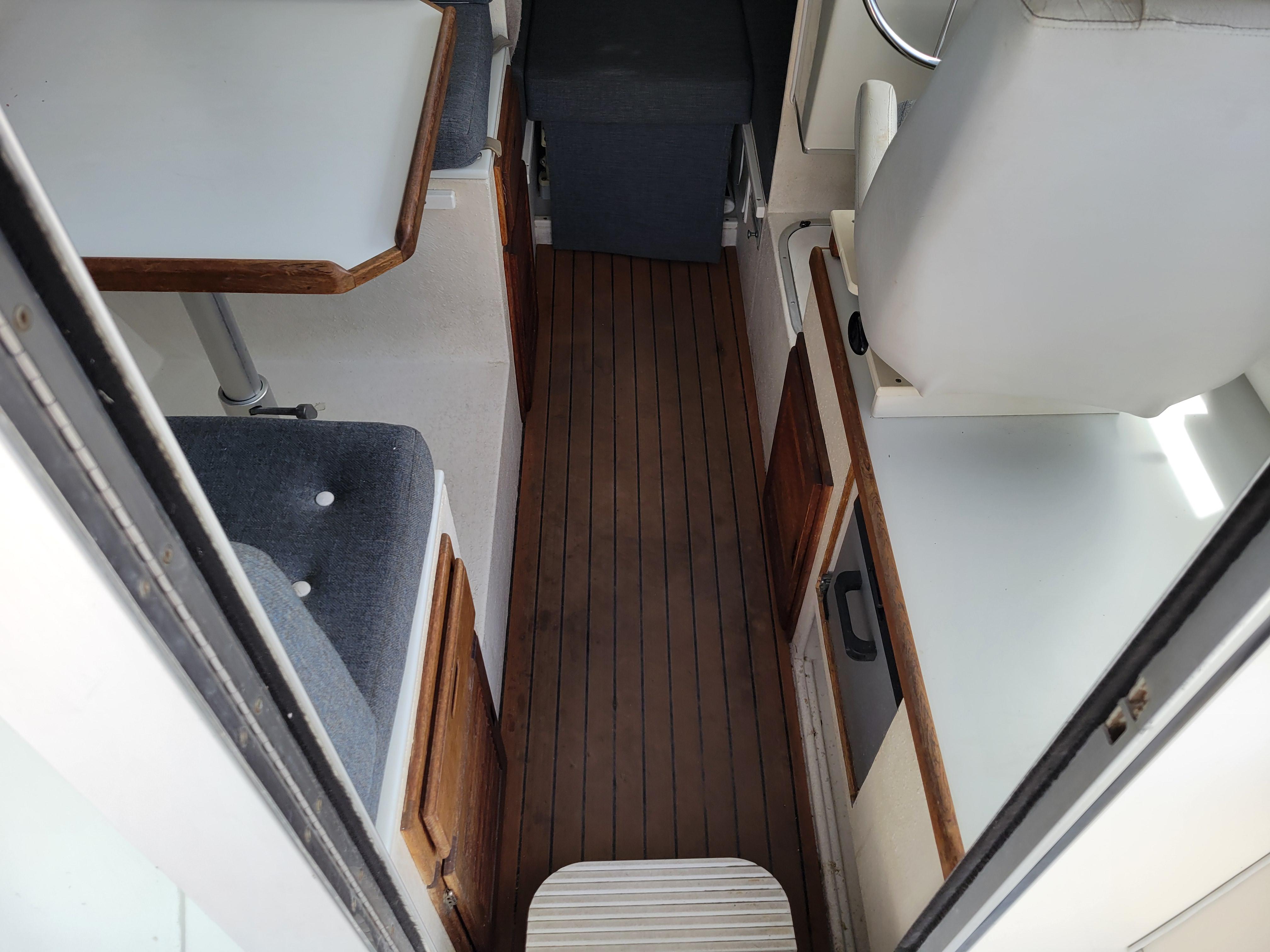 Interior of 1999 SeaSport 2400 XL Limited boat with wood flooring and seating area.