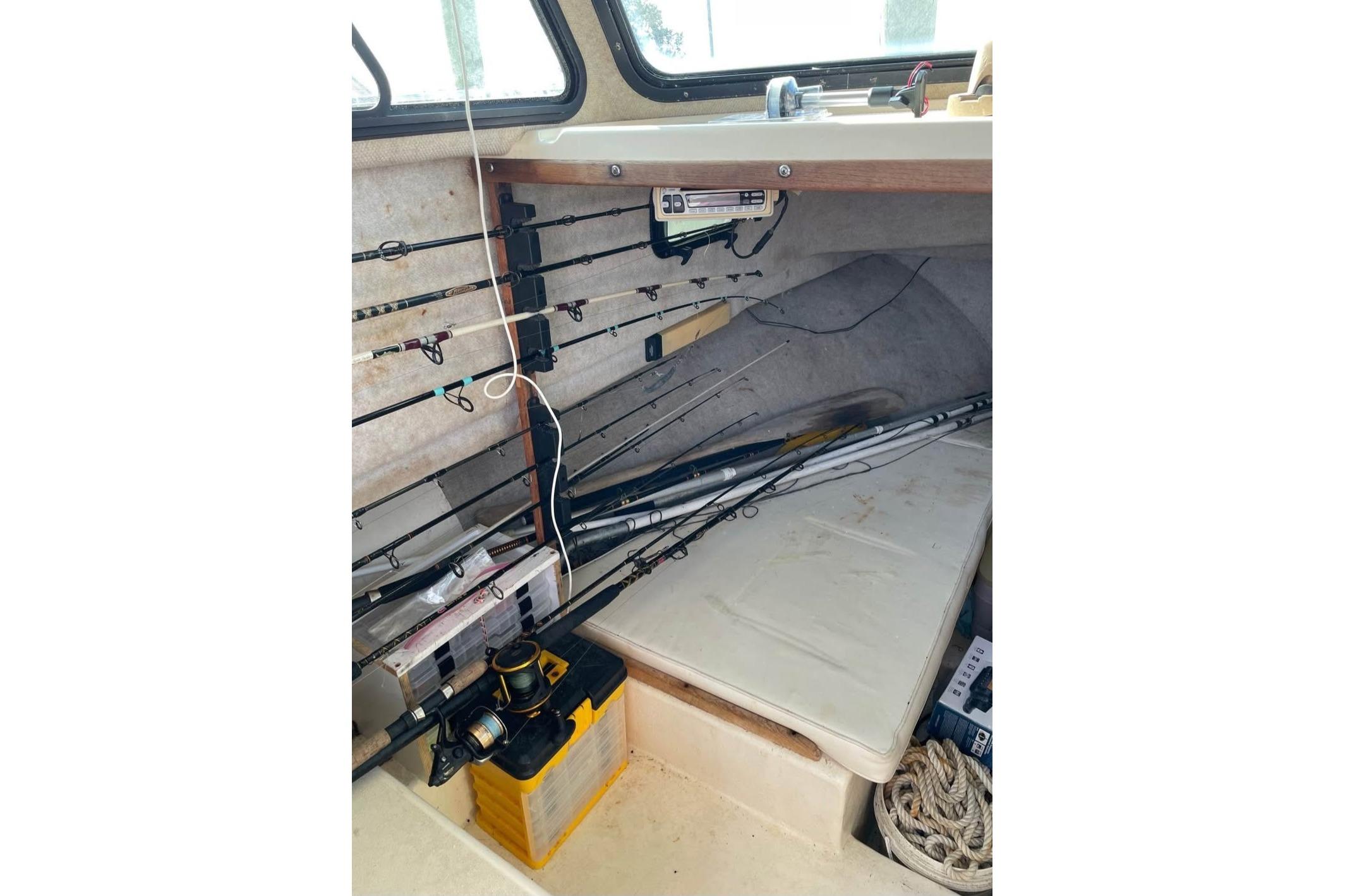 Interior of 2002 Parker 2520 Deep Vee Sport Cabin with fishing rods and equipment.