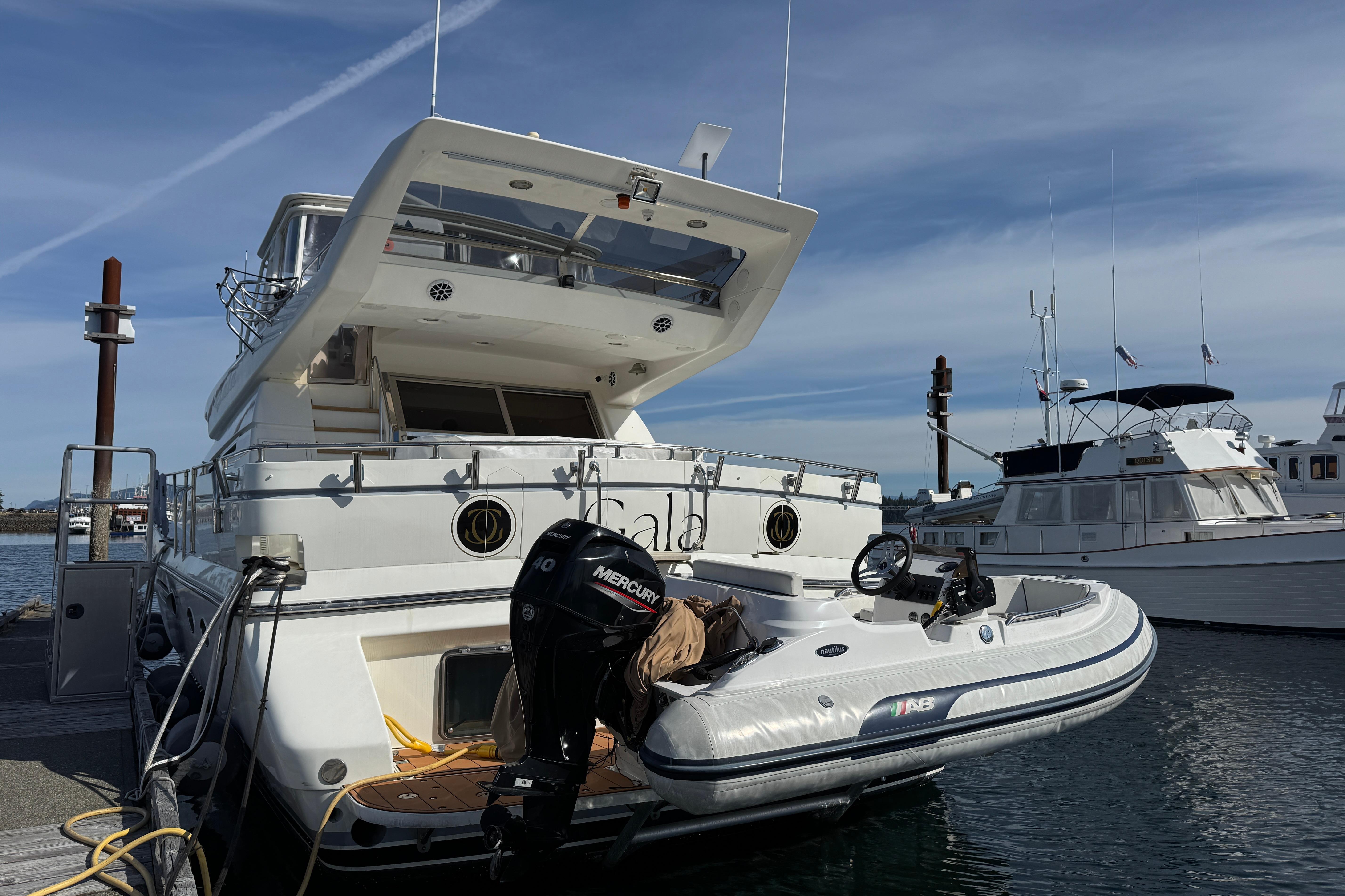 Luxury yacht "Johnson High-Tech 65 Euro" 1994 model docked with inflatable boat.