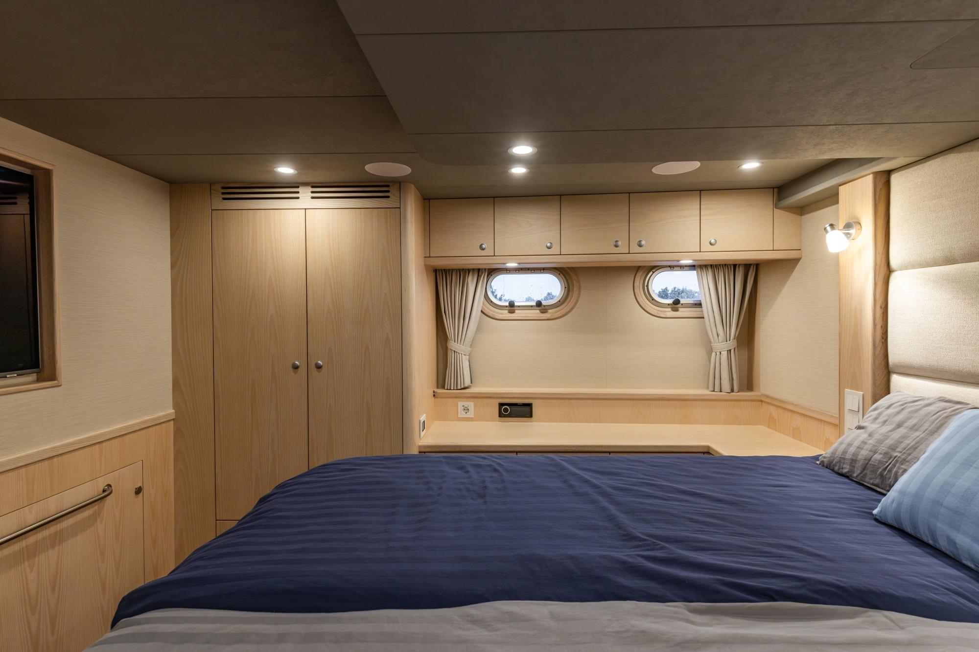 Luxurious cabin interior of 2025 Elling E6 yacht with cozy bed and elegant wood finishes.