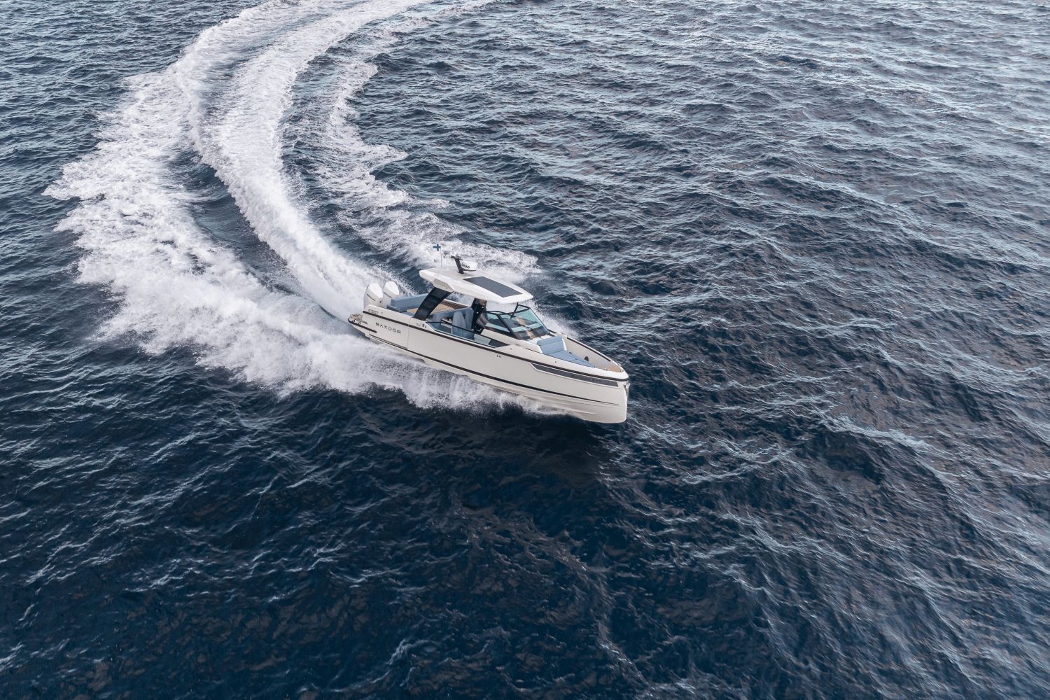 A 2027 Saxdor SX320 GTO speeds across open water, leaving a white wake behind.