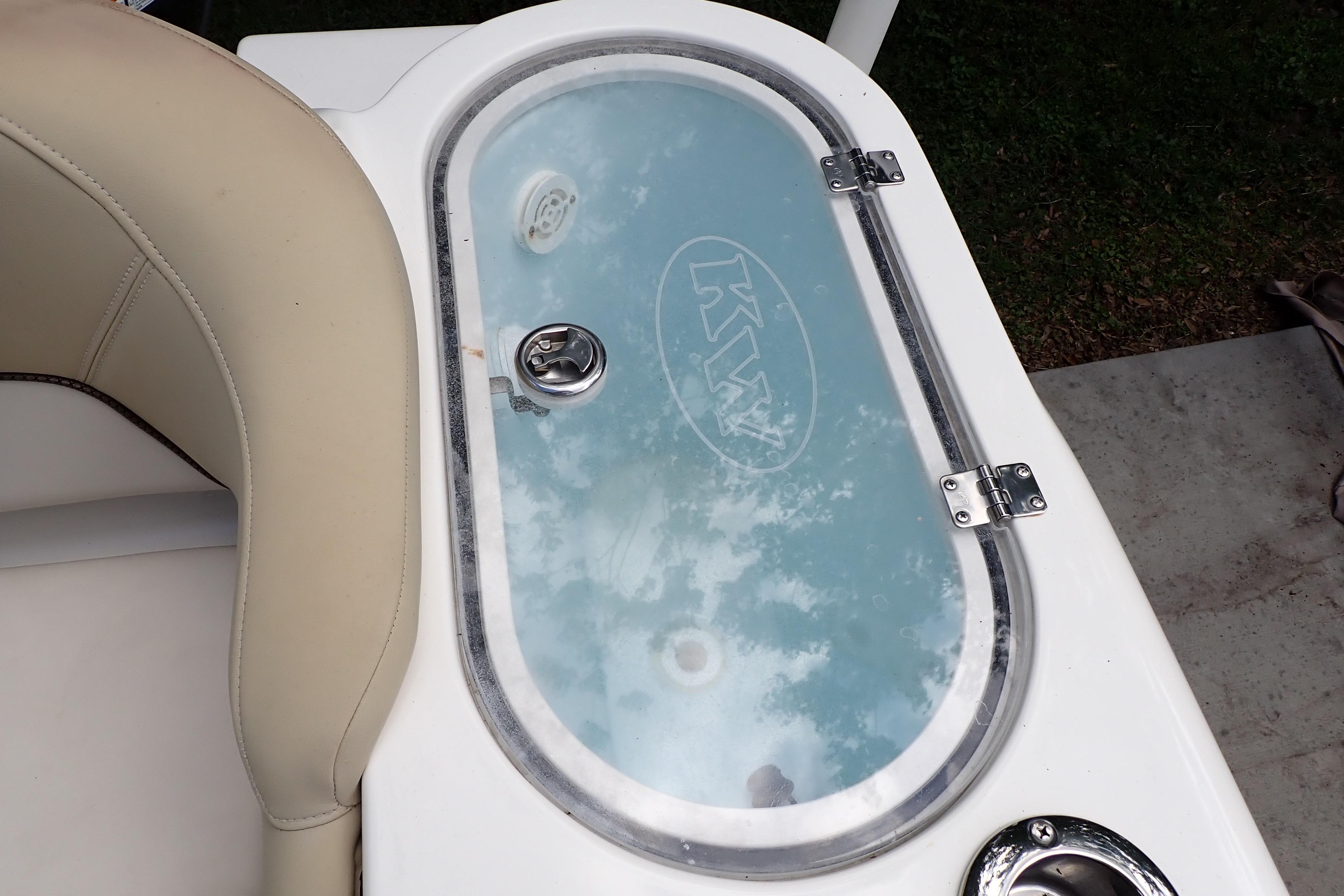 2019 Key West 263 FS boat livewell with transparent lid and beige seating.