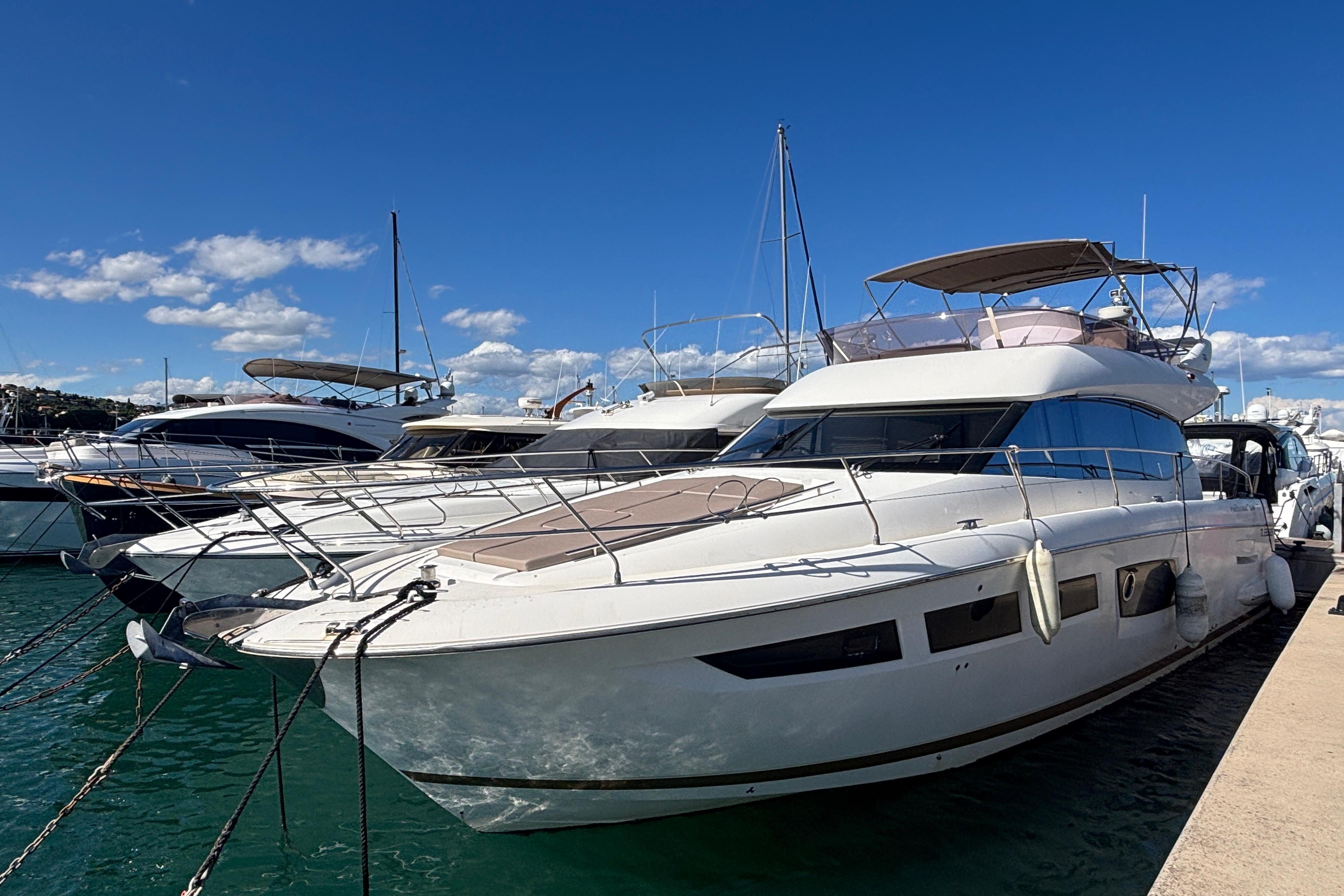 Luxury 2012 Prestige 500 yacht docked at marina under clear blue sky.