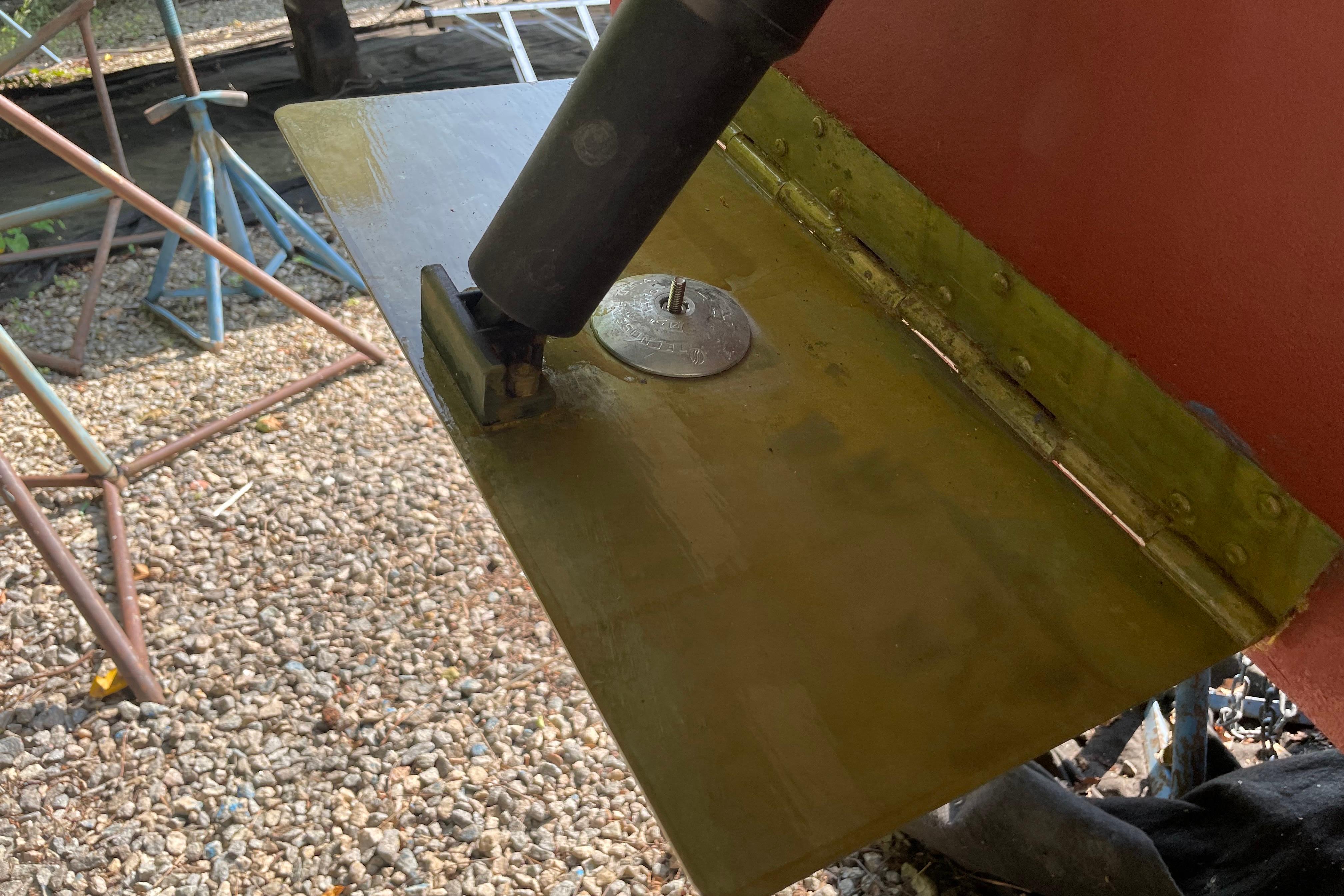 2007 Back Cove 29 boat rudder and propeller shaft detail on gravel surface.