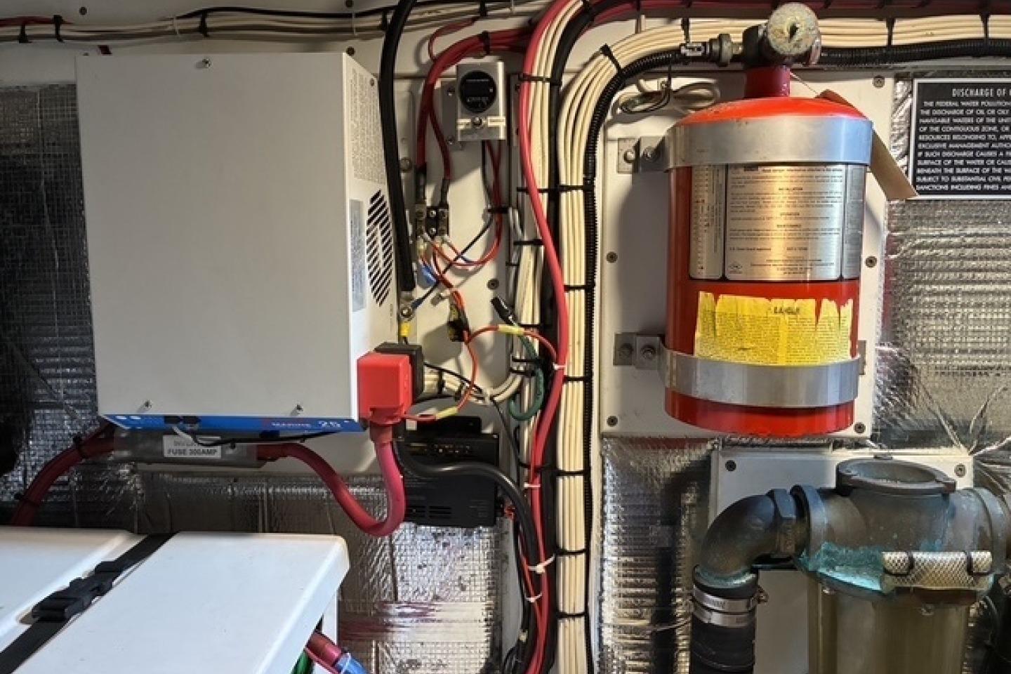 Engine room of a 2000 Nordic Tug 37 with fire extinguisher and wiring.