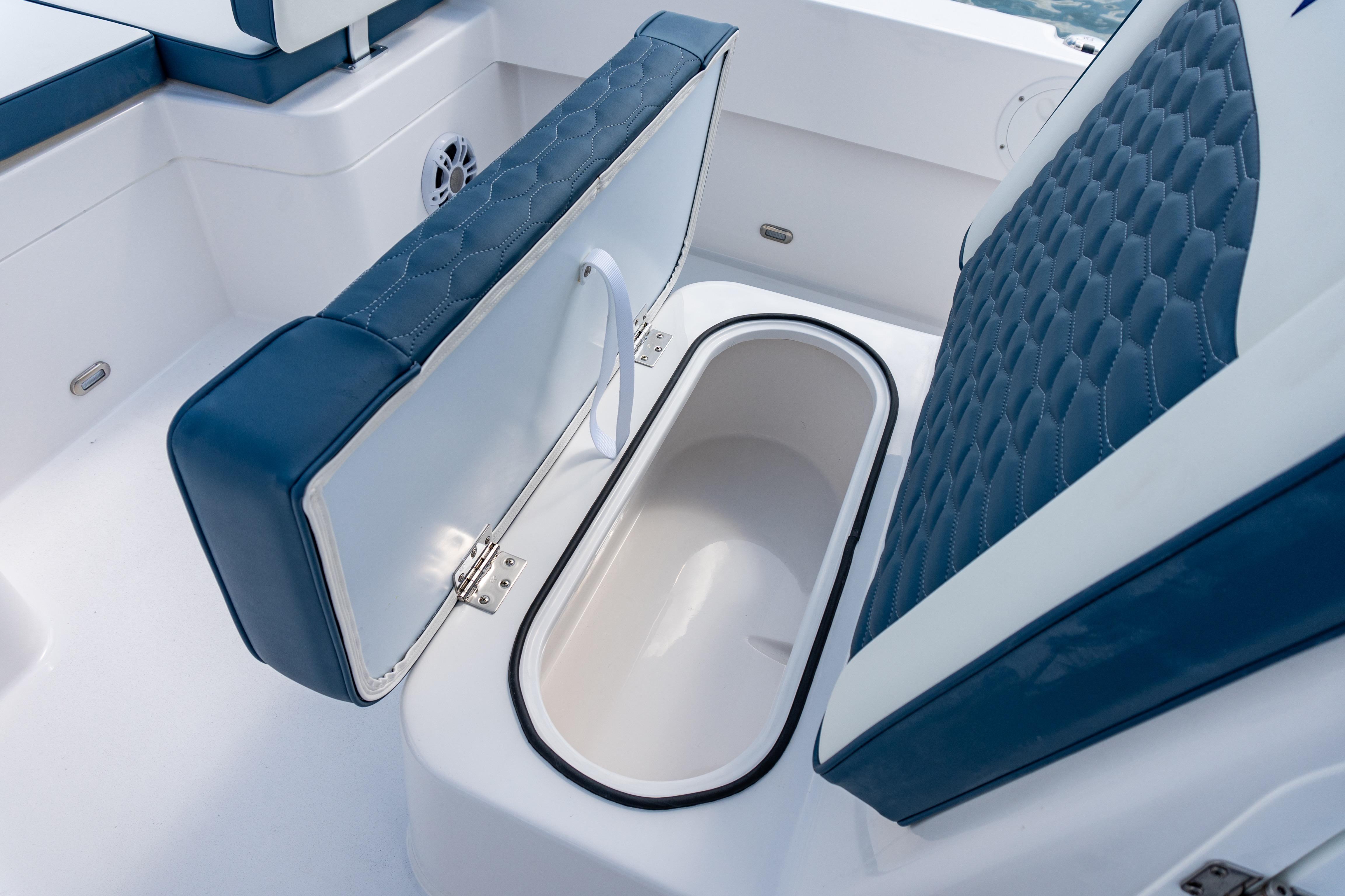2026 Twin Vee 22 BayCat boat seat with storage compartment open.