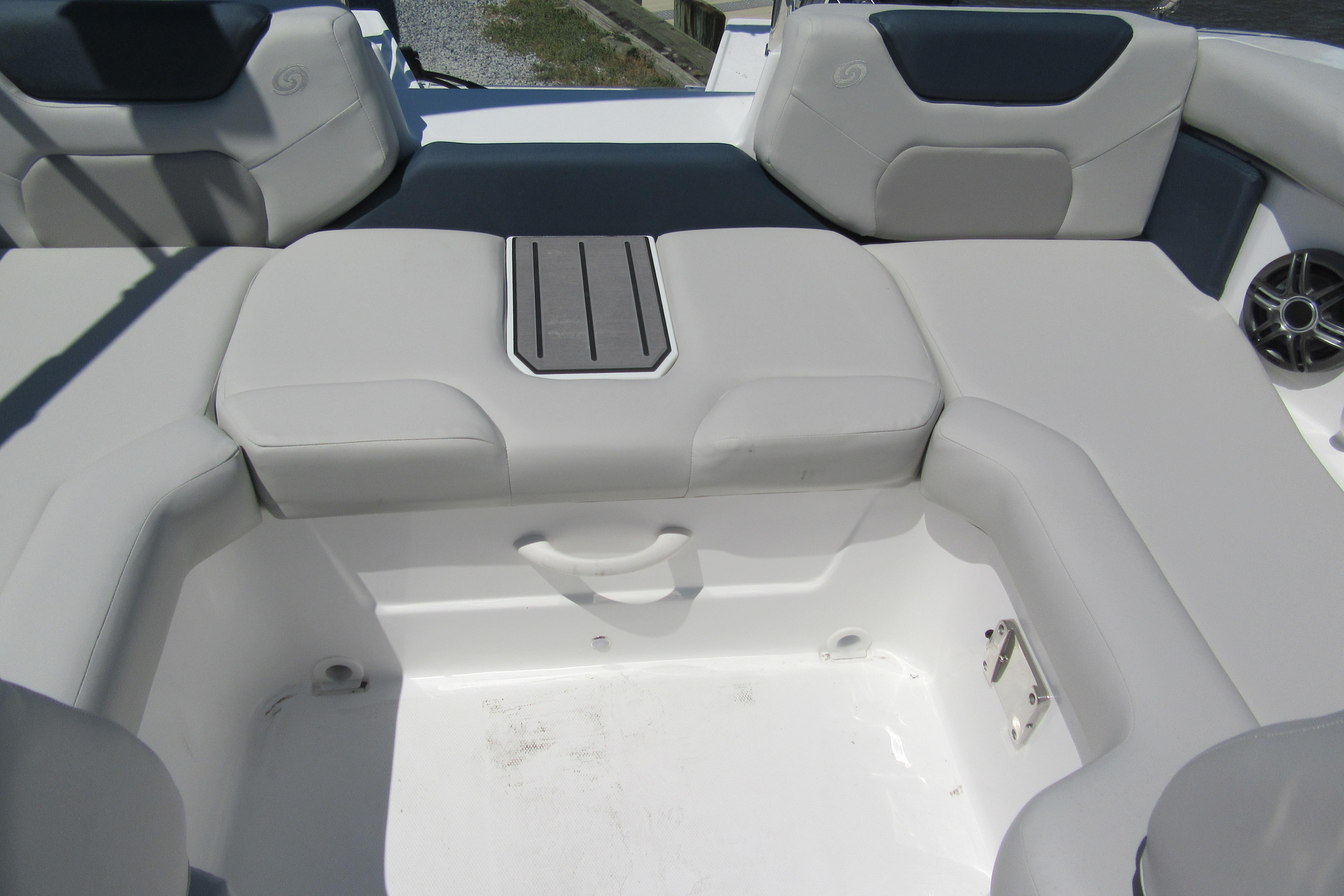 2027 Hurricane SunDeck 2050 OB boat interior with cushioned seating and storage compartment.