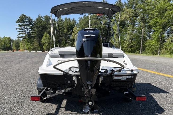 2026 Tahoe T16 boat with outboard motor on a trailer, parked in a scenic outdoor setting.
