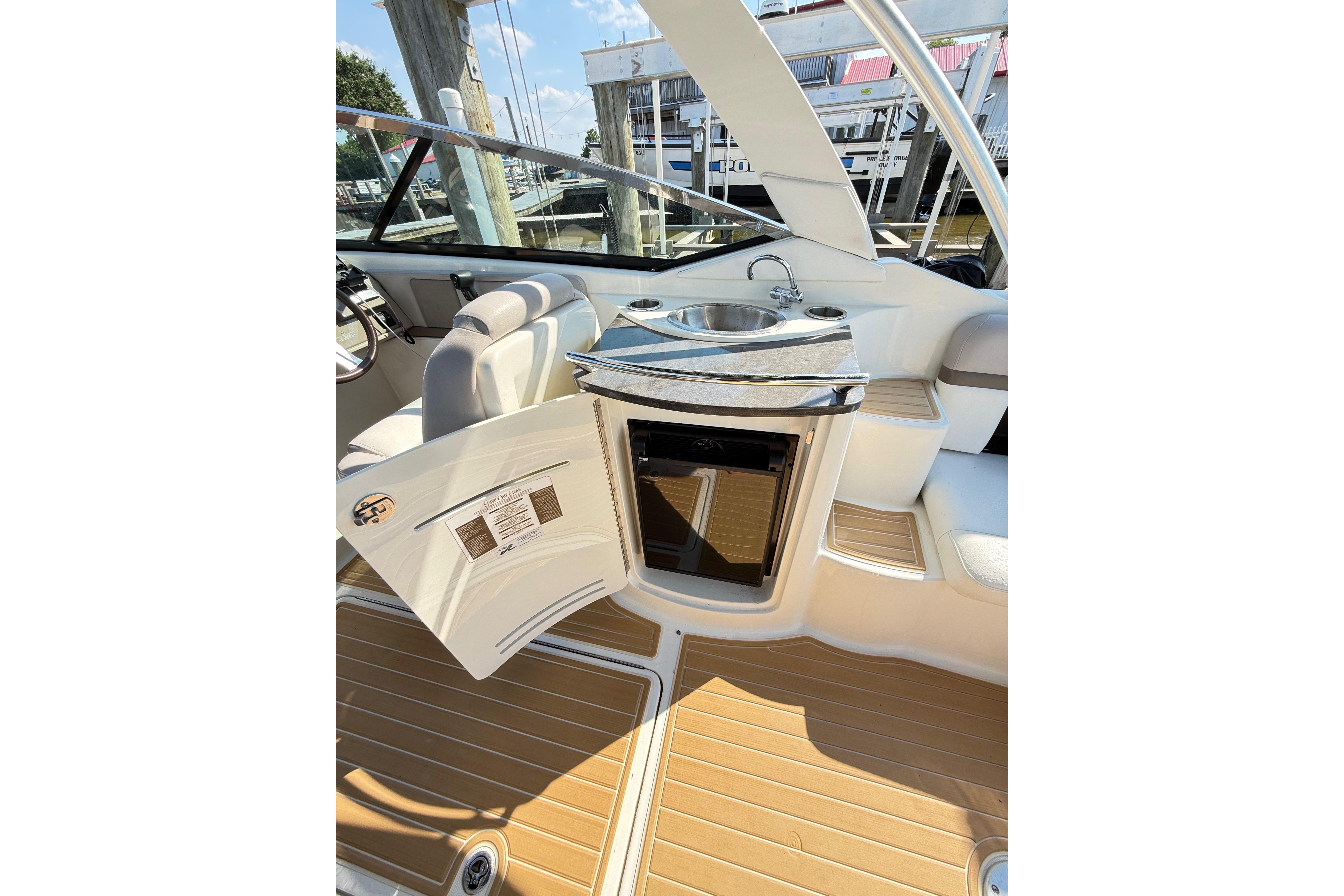 2011 Sea Ray 270 SLX boat interior with sink, seating, and open storage compartment.