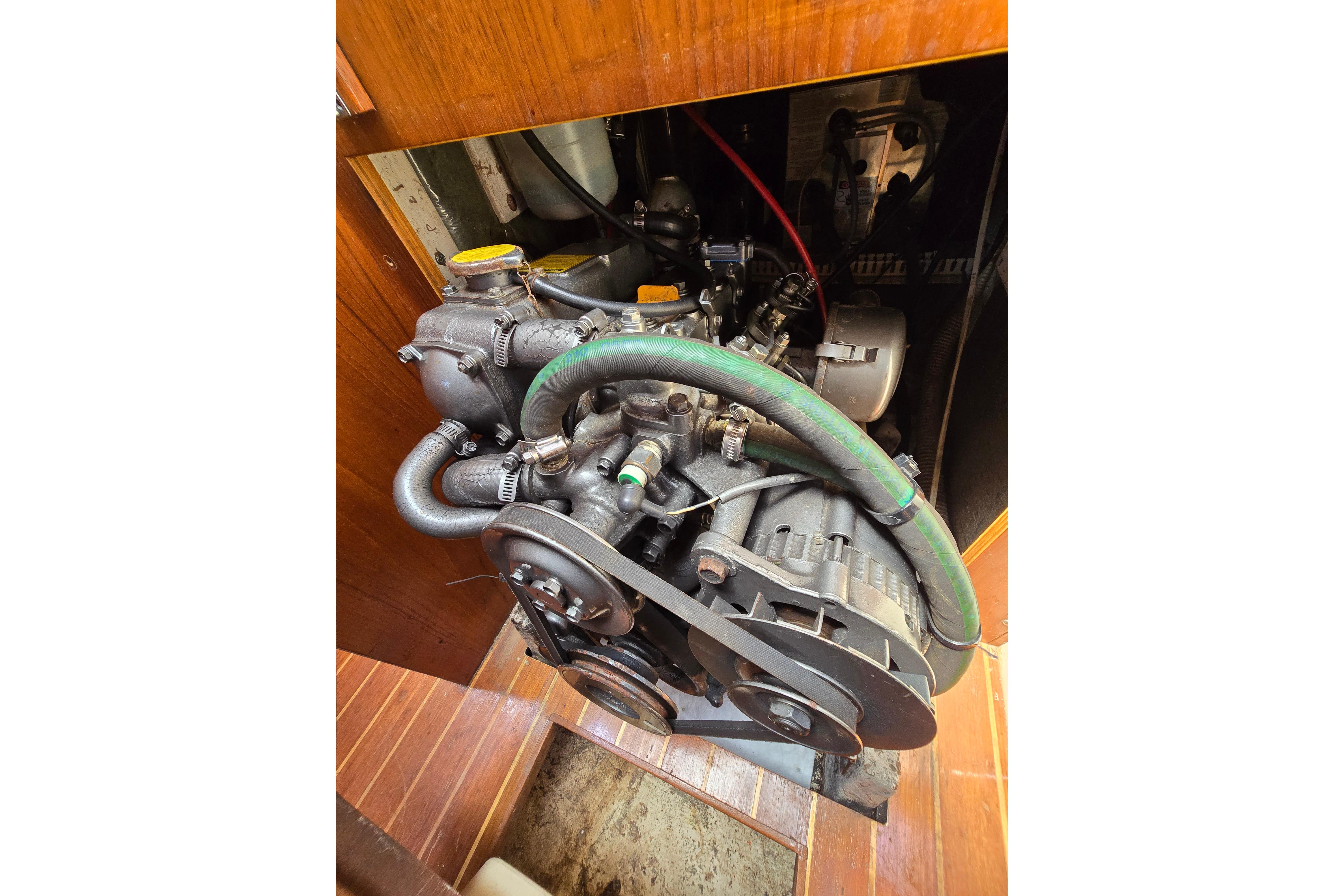 Engine compartment of a 1993 Caliber 35 sailboat, showcasing mechanical components and hoses.