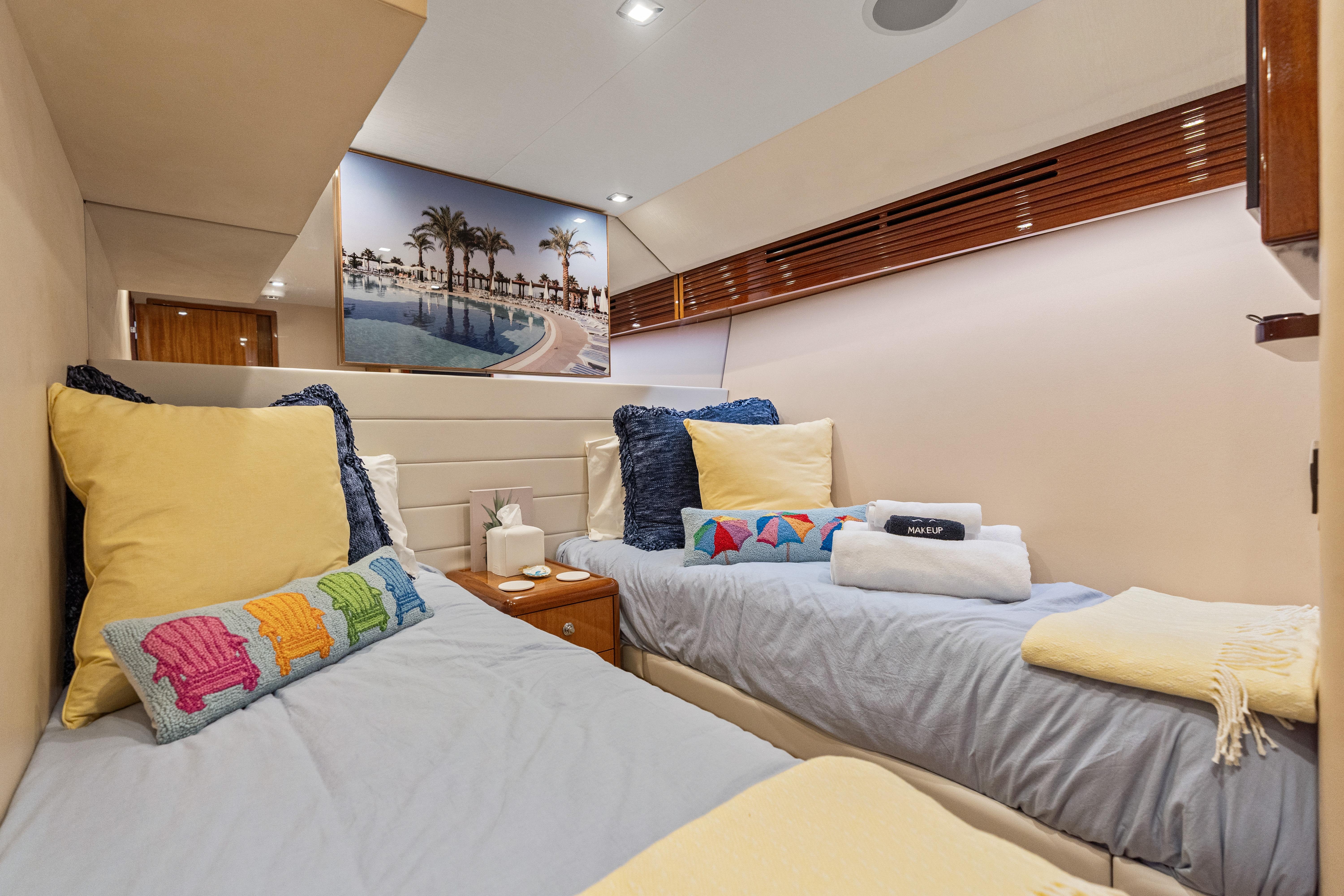 Interior of 2008 Hatteras 64 Motor Yacht with twin beds and decorative pillows.