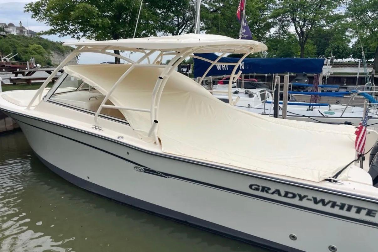 2019 Grady-White Freedom 307 boat docked, featuring a sleek design and protective canopy.