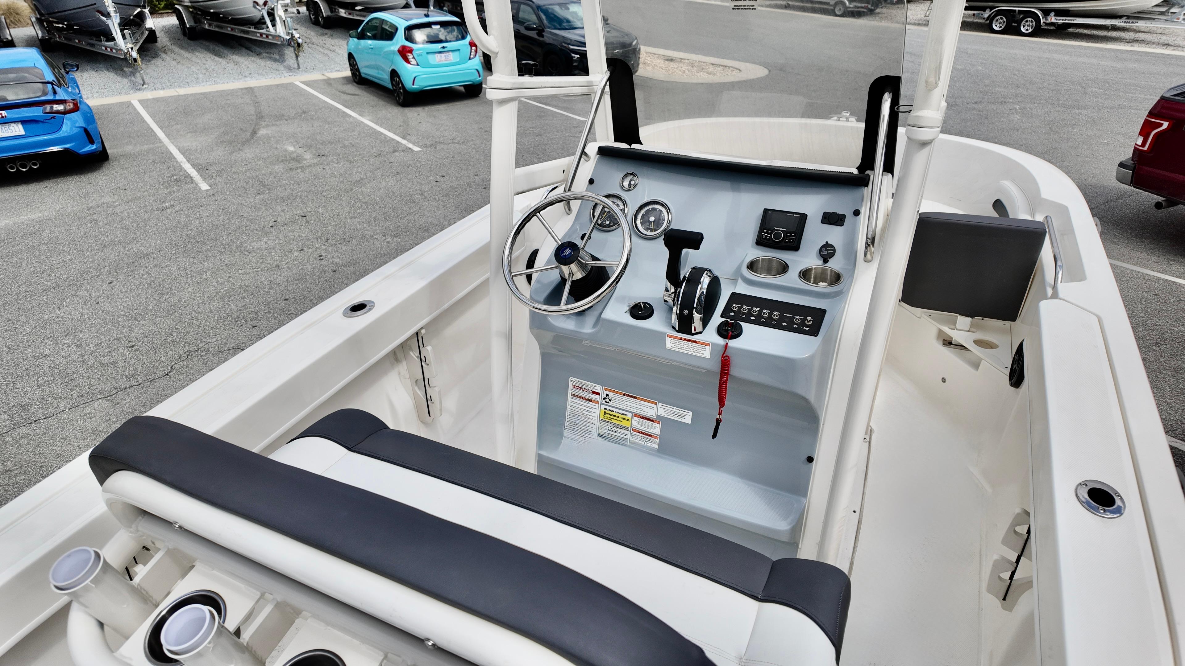 2025 Bayliner Trophy 20 boat interior with steering console and seating in a parking lot.
