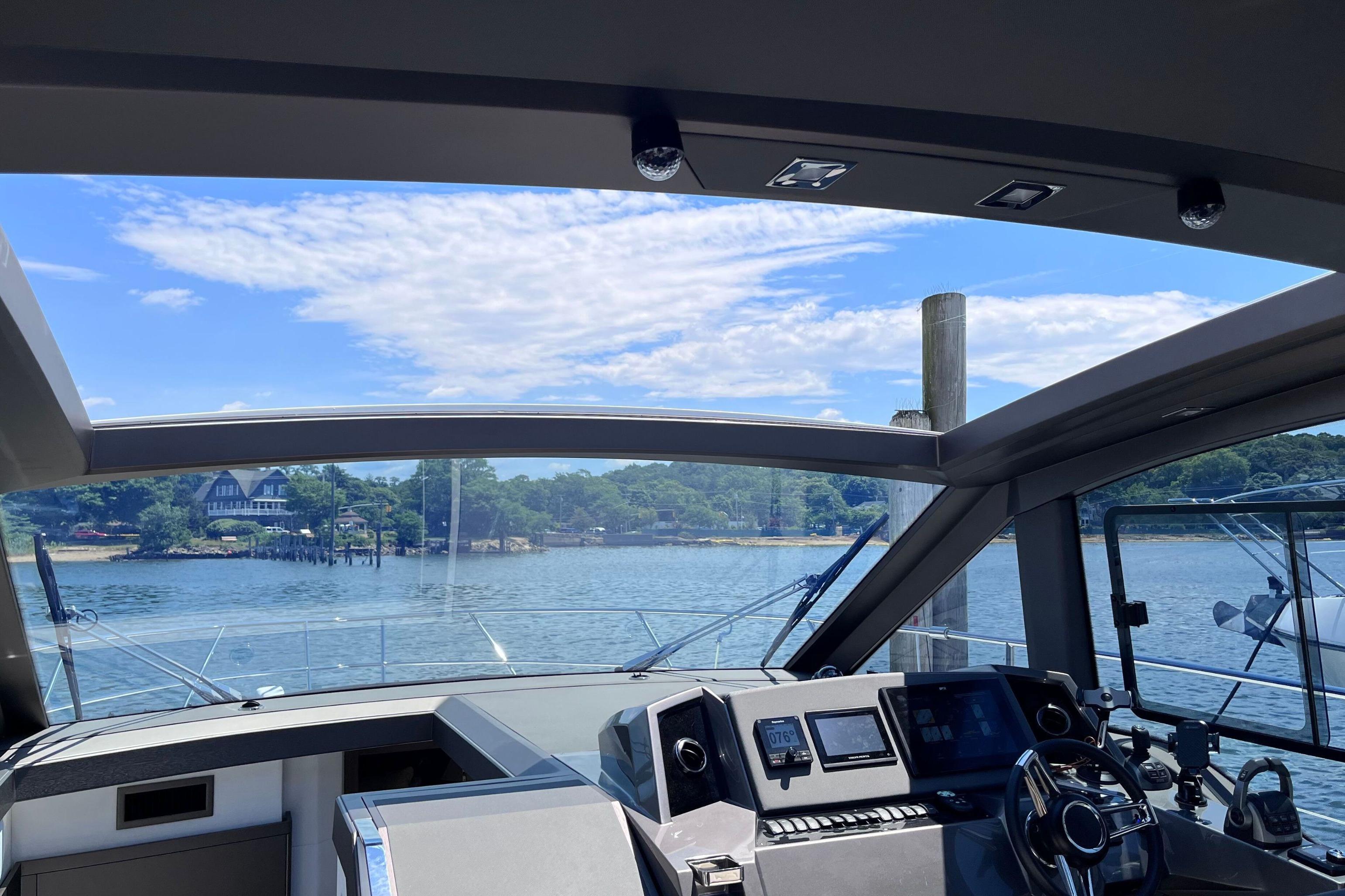 2024 Galeon 425 HTS yacht cockpit with scenic waterfront view.