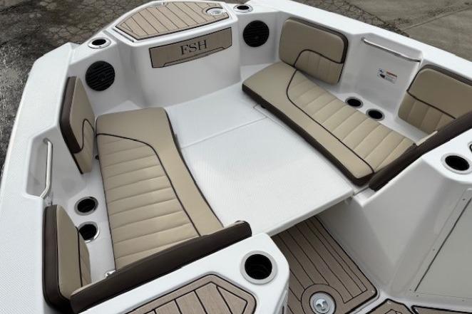 2026 Yamaha Boats 222 FSH Sport E interior with beige seating and cup holders.