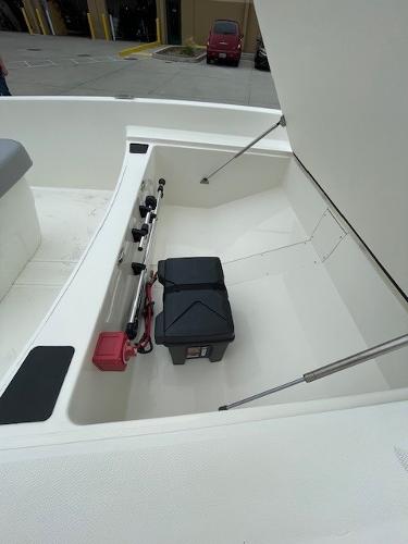 2025 Mako Pro Skiff 17 CC boat storage compartment with battery and rods.