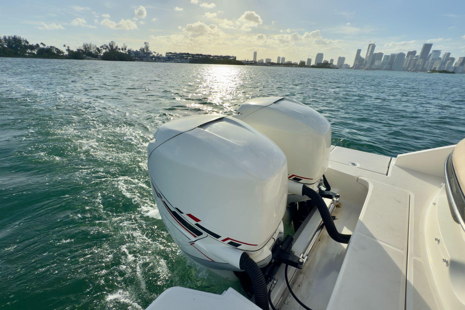 2017 Sea Ray SLX 310 Outboard cruising on sunny waters near city skyline.