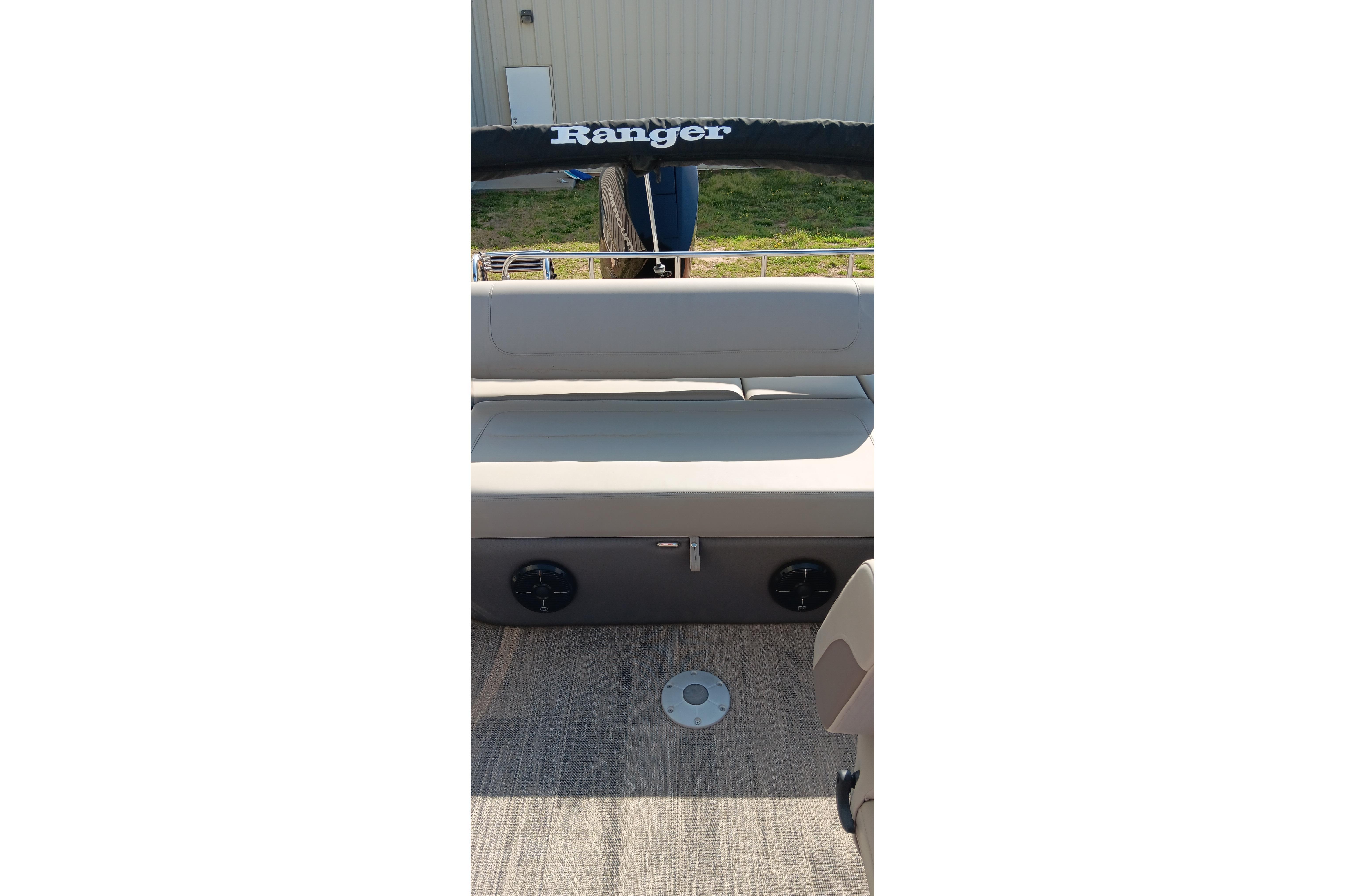 2023 Ranger 2500LS boat interior with cushioned seating and wood-textured flooring.