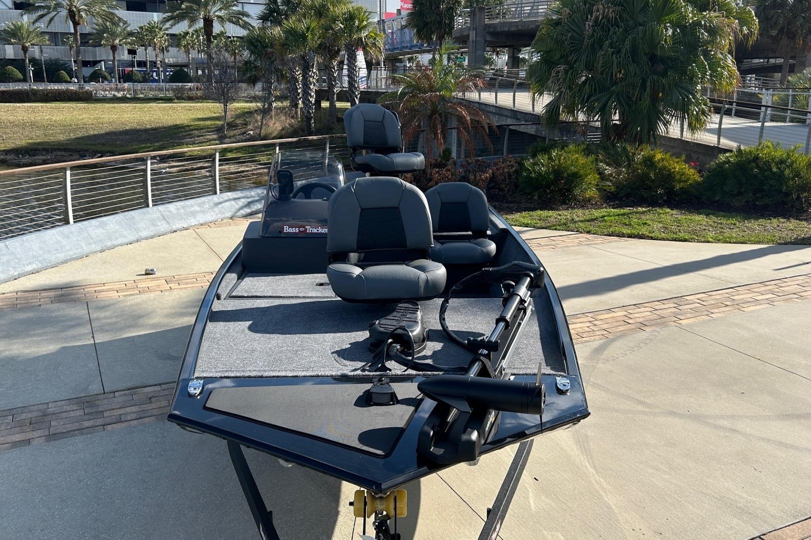 2026 Tracker Bass Tracker Classic XL boat parked near palm trees and walkway.
