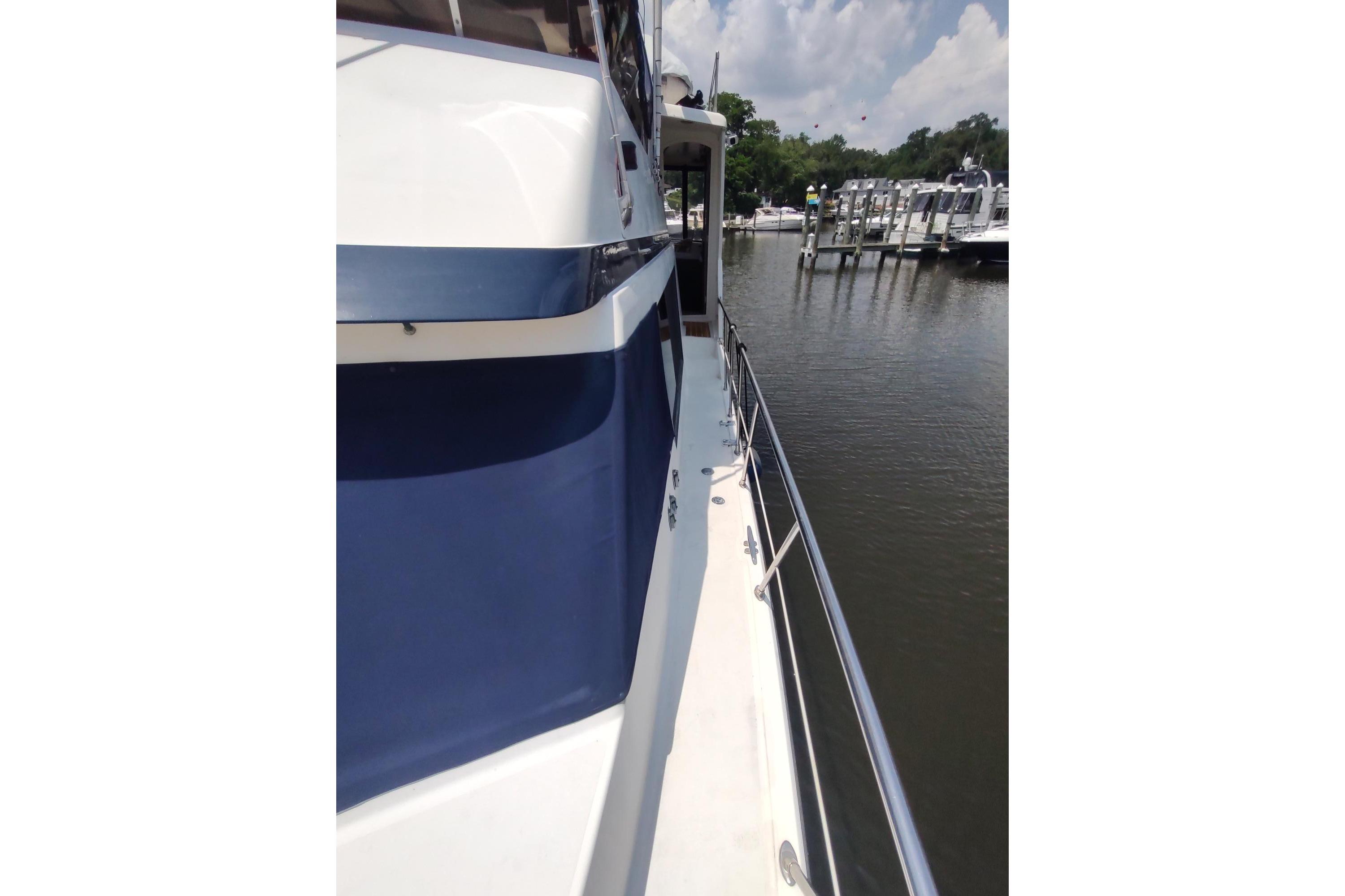 1989 Hyatt Double Cabin Motoryacht docked by a serene marina under a cloudy sky.