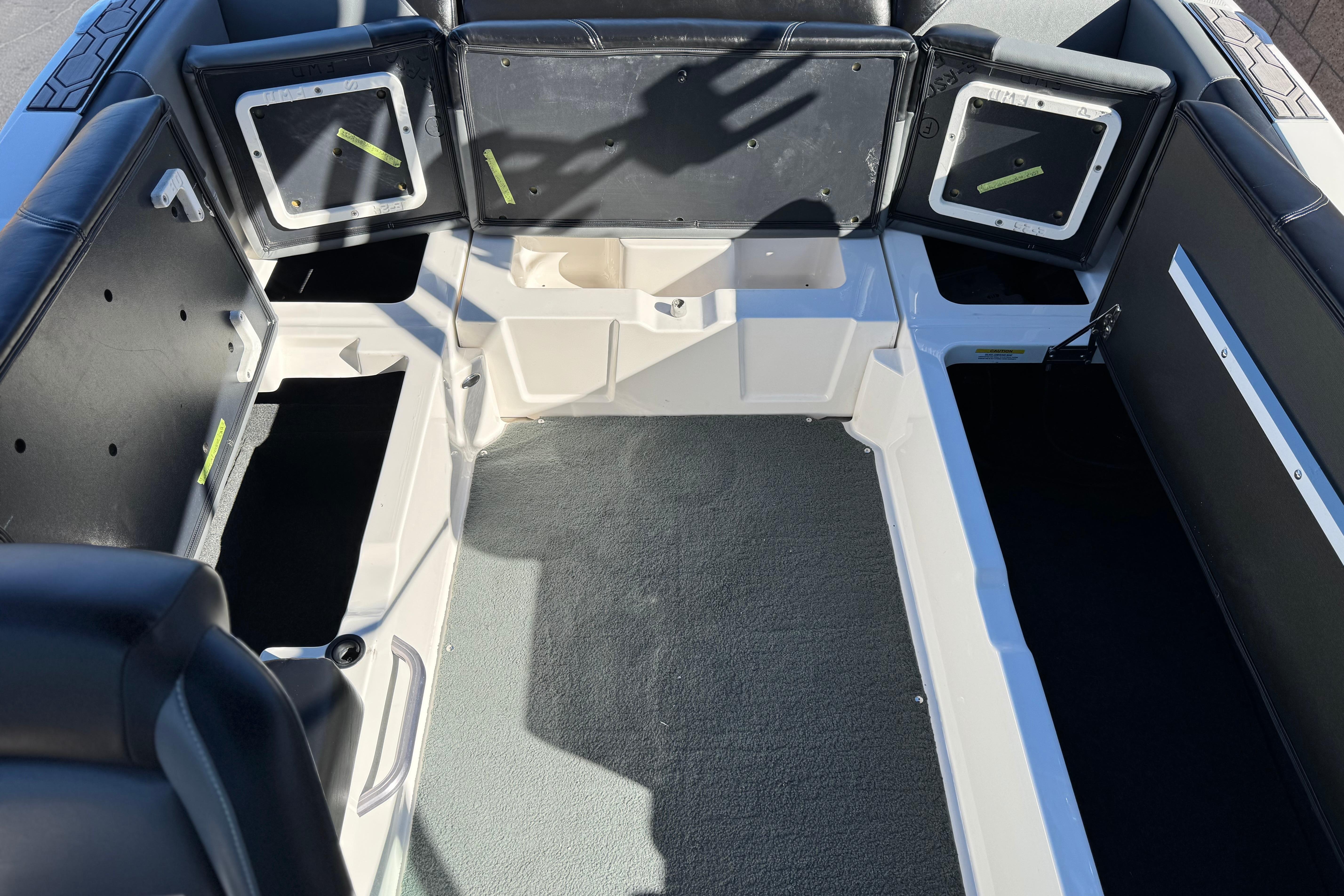 2023 MasterCraft NXT22 boat interior with open storage compartments and seating.
