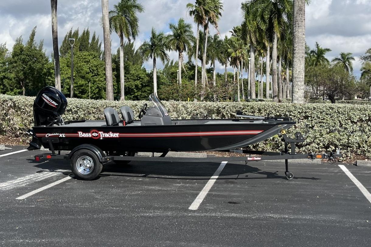 2026 Tracker Bass Tracker Classic XL boat parked in a lot with palm trees.