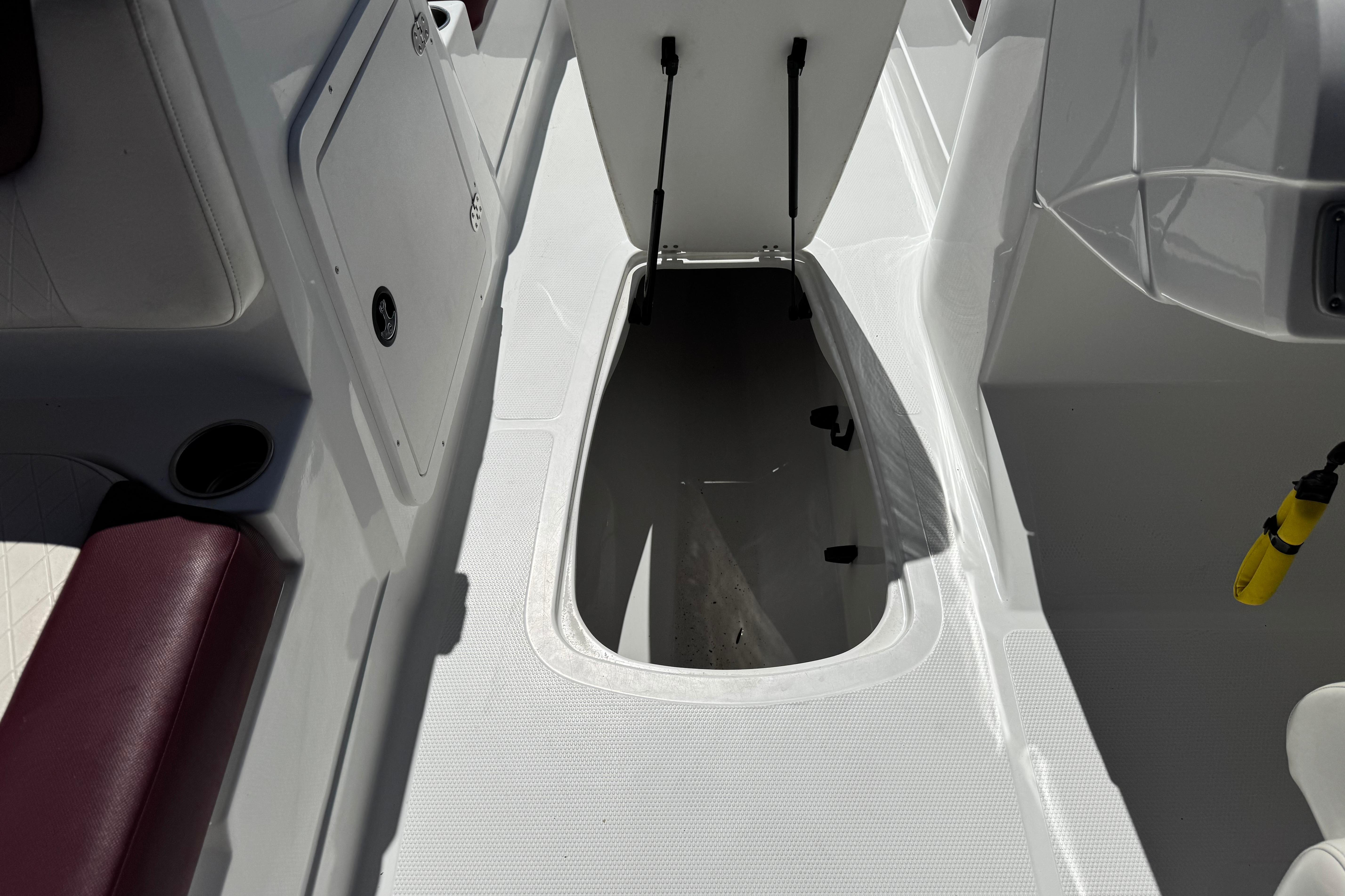 2017 Tahoe 2150 boat interior storage compartment with open hatch and seating area.