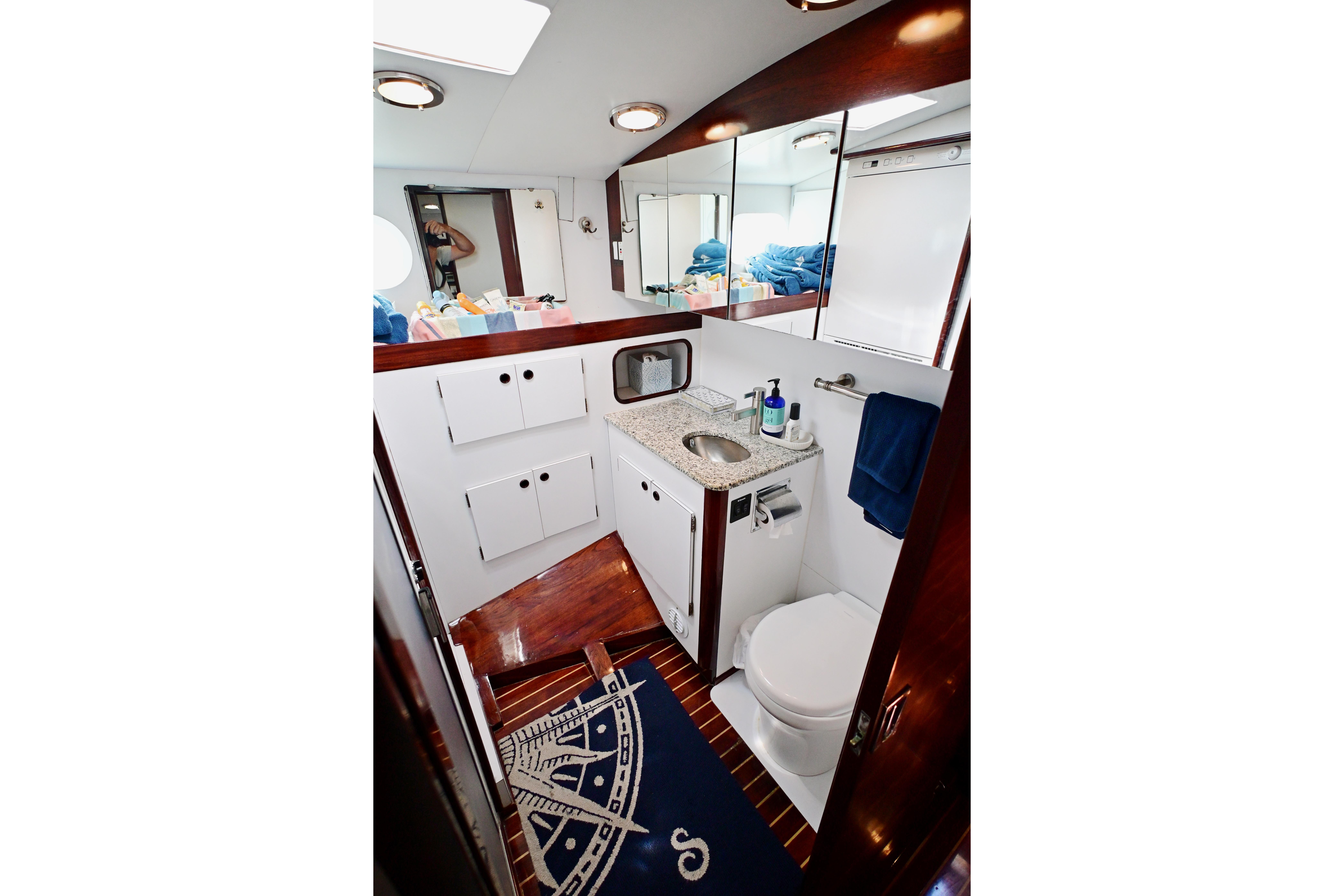 Luxurious yacht bathroom with modern fixtures, wooden accents, and nautical-themed decor. Abeking & Rasmussen Tripp 74, 1968.