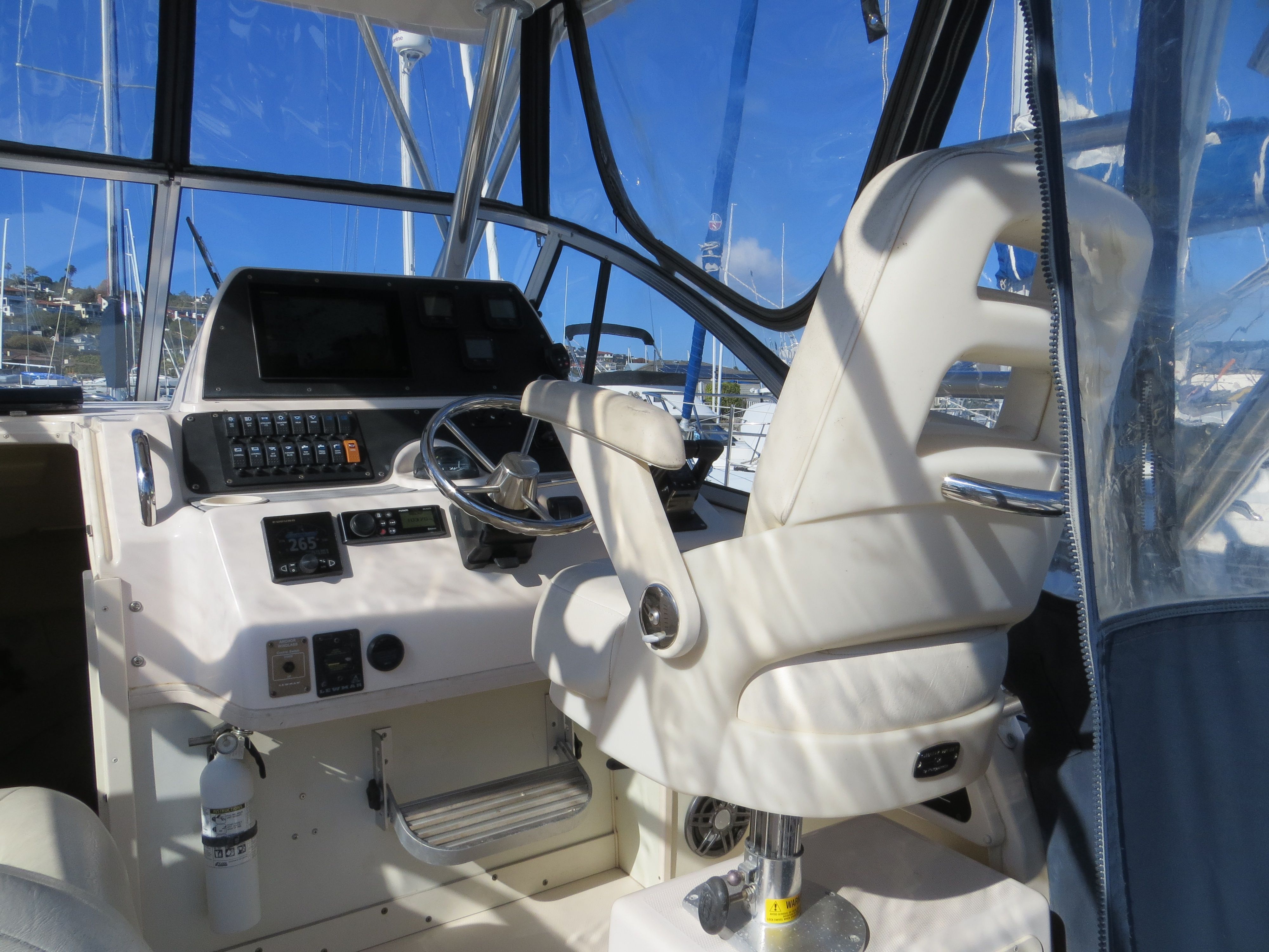 The image shows the cockpit of a 2007 Grady-White Sailfish 282 with a white helm chair.