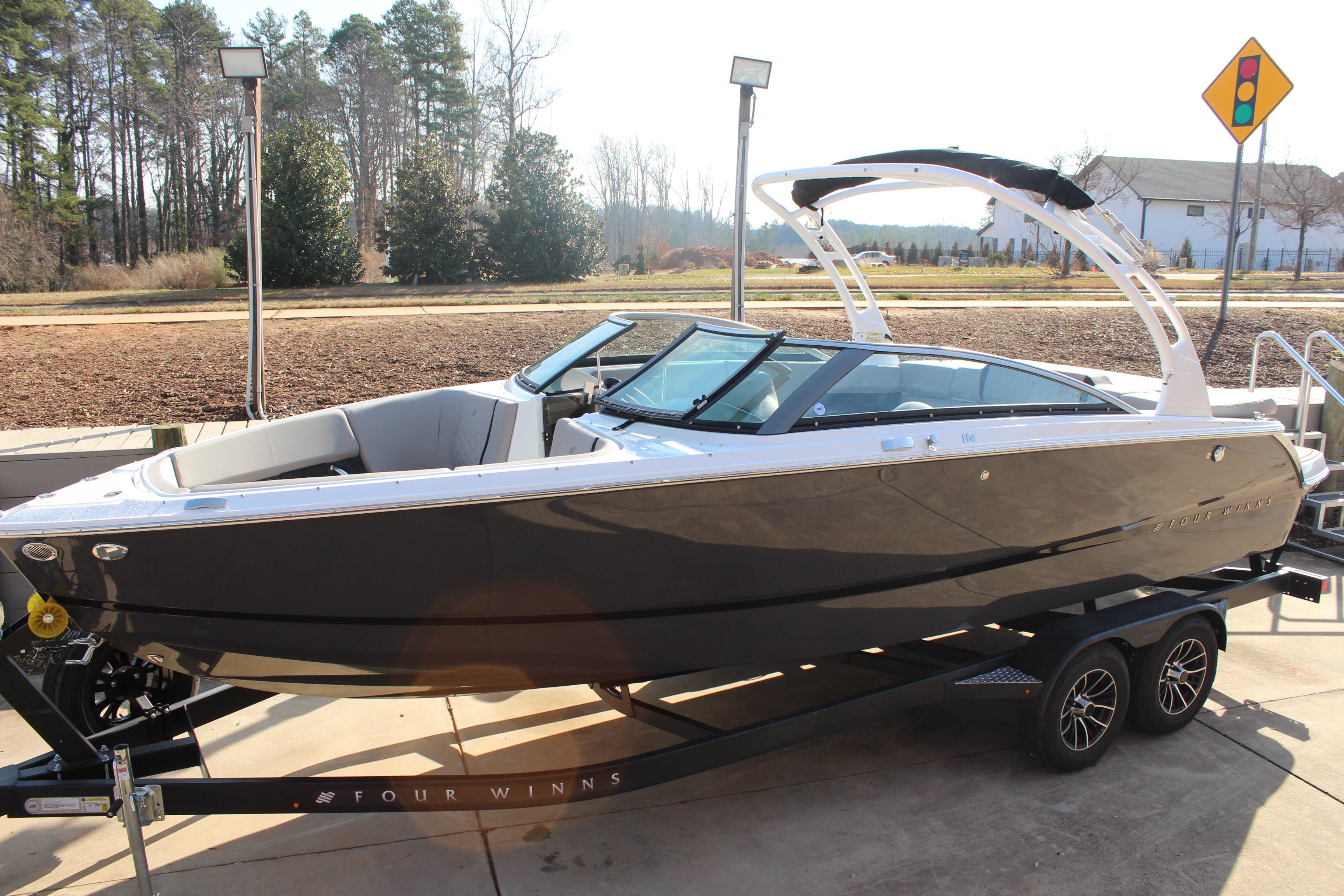 2026 Four Winns H4 boat on trailer, sleek design, parked outdoors.