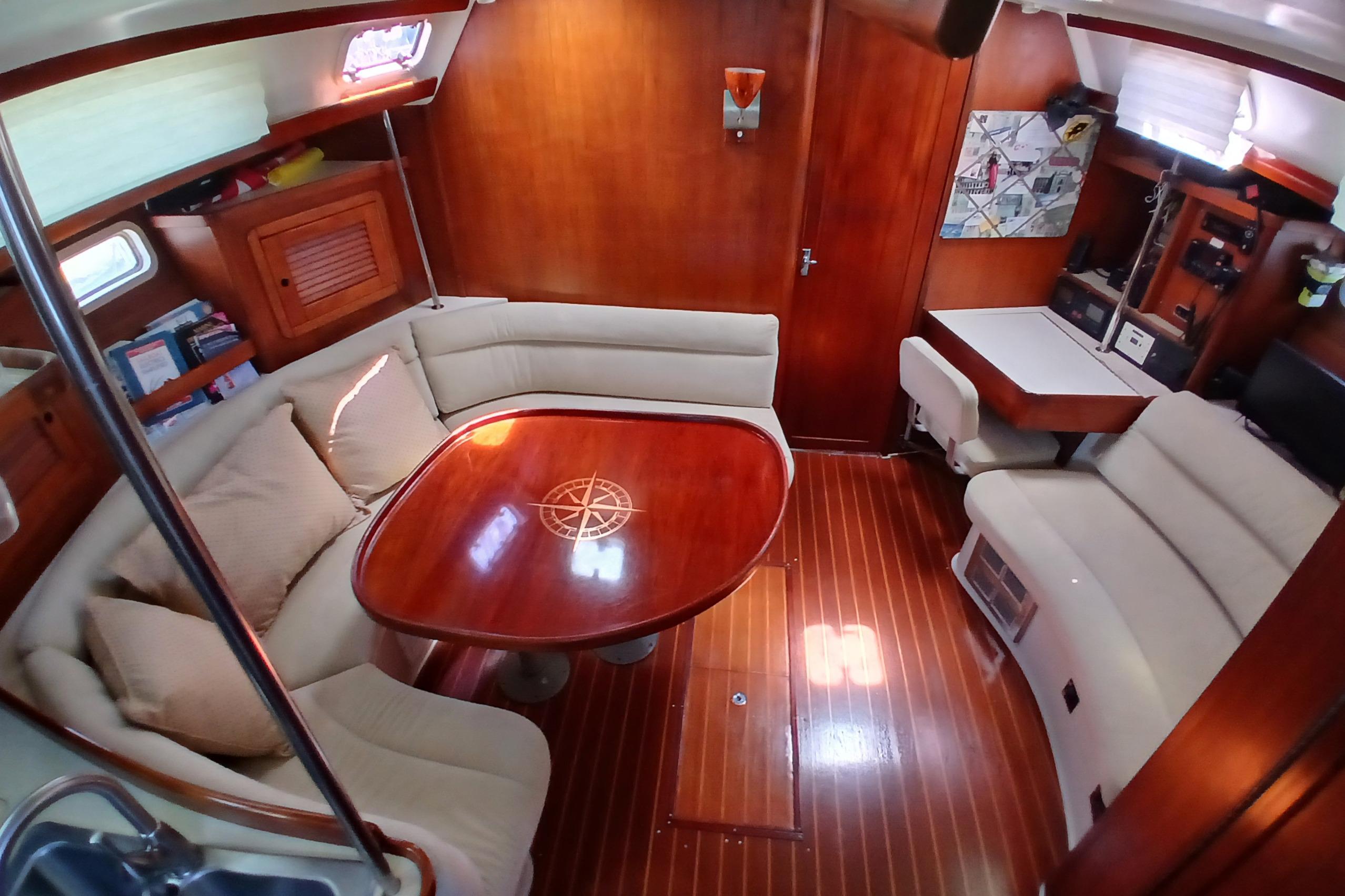 Interior of a 1995 Catalina 42 MkII sailboat with wooden finishes and cozy seating.