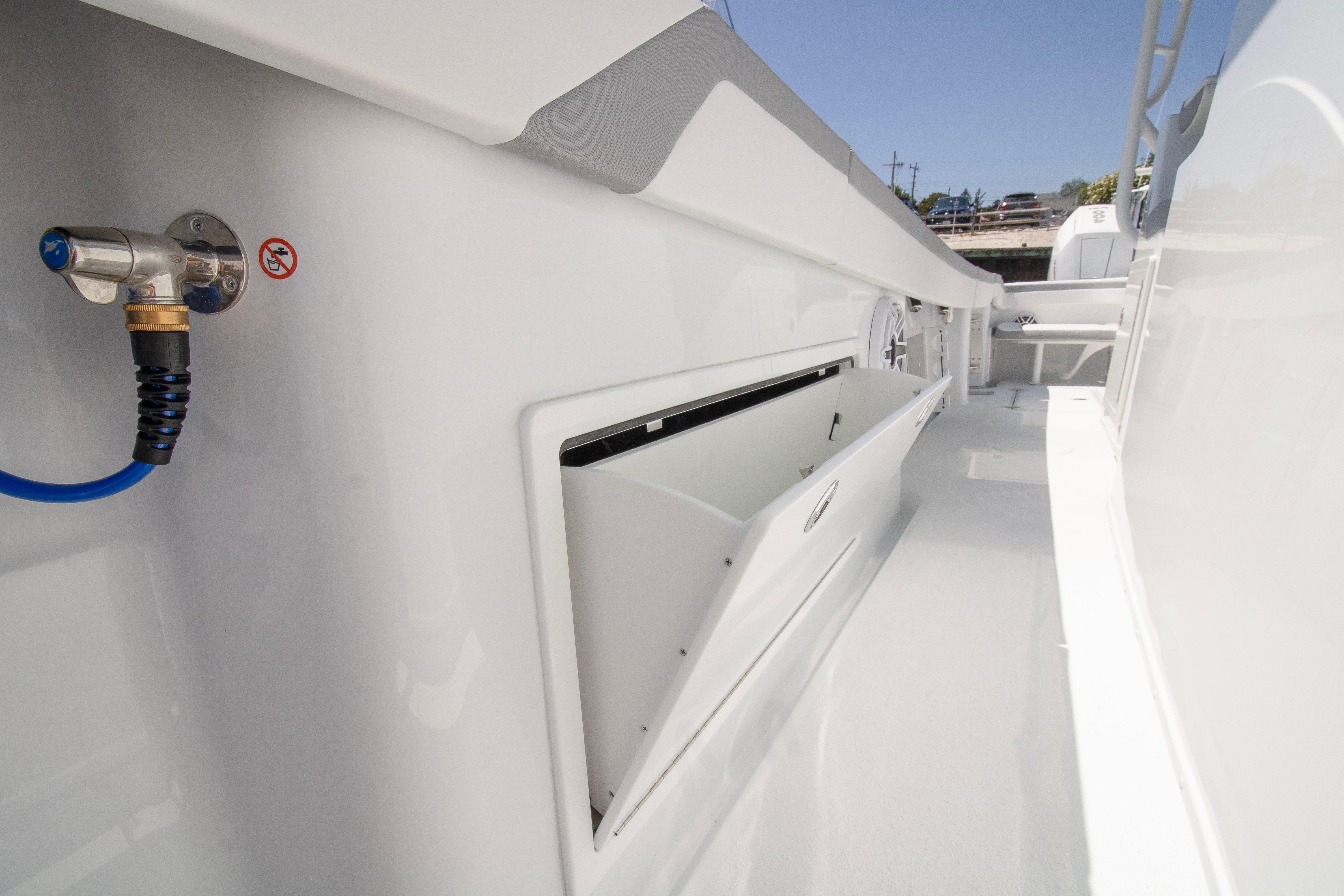 2026 Yellowfin 42 Offshore boat deck with storage compartment and hose connection.
