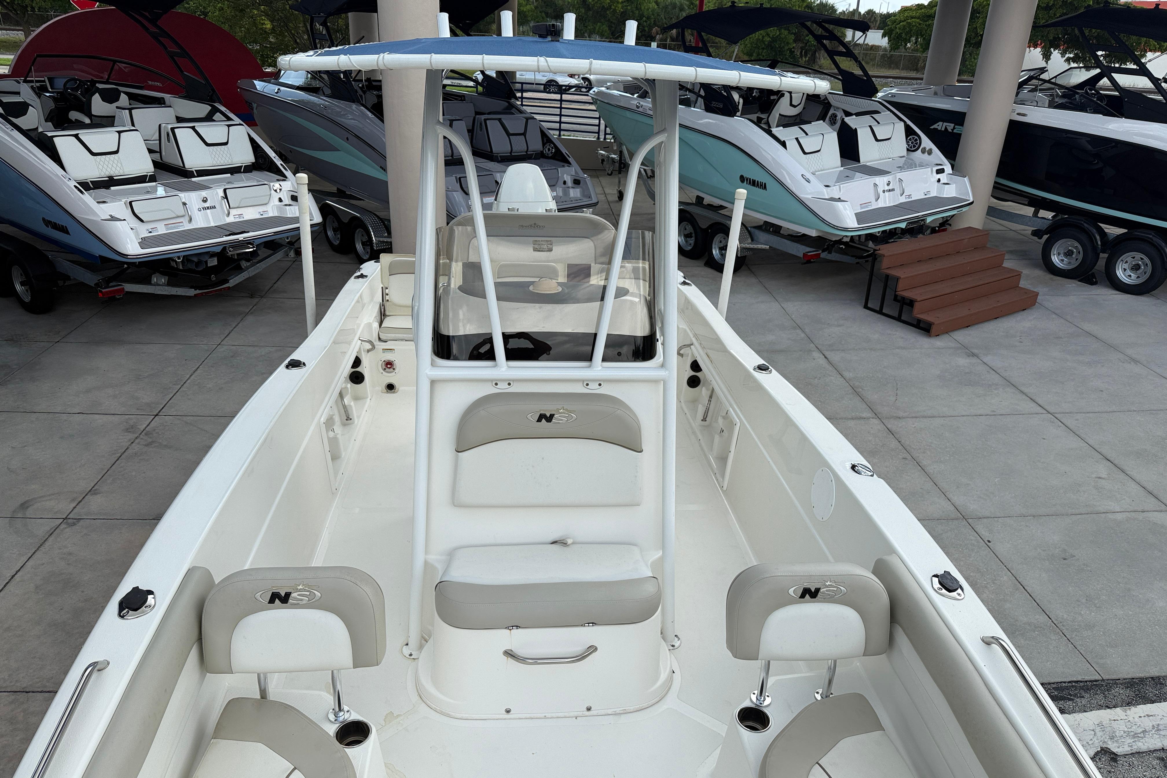 2015 NauticStar 231 Coastal boat displayed in a showroom with other boats.
