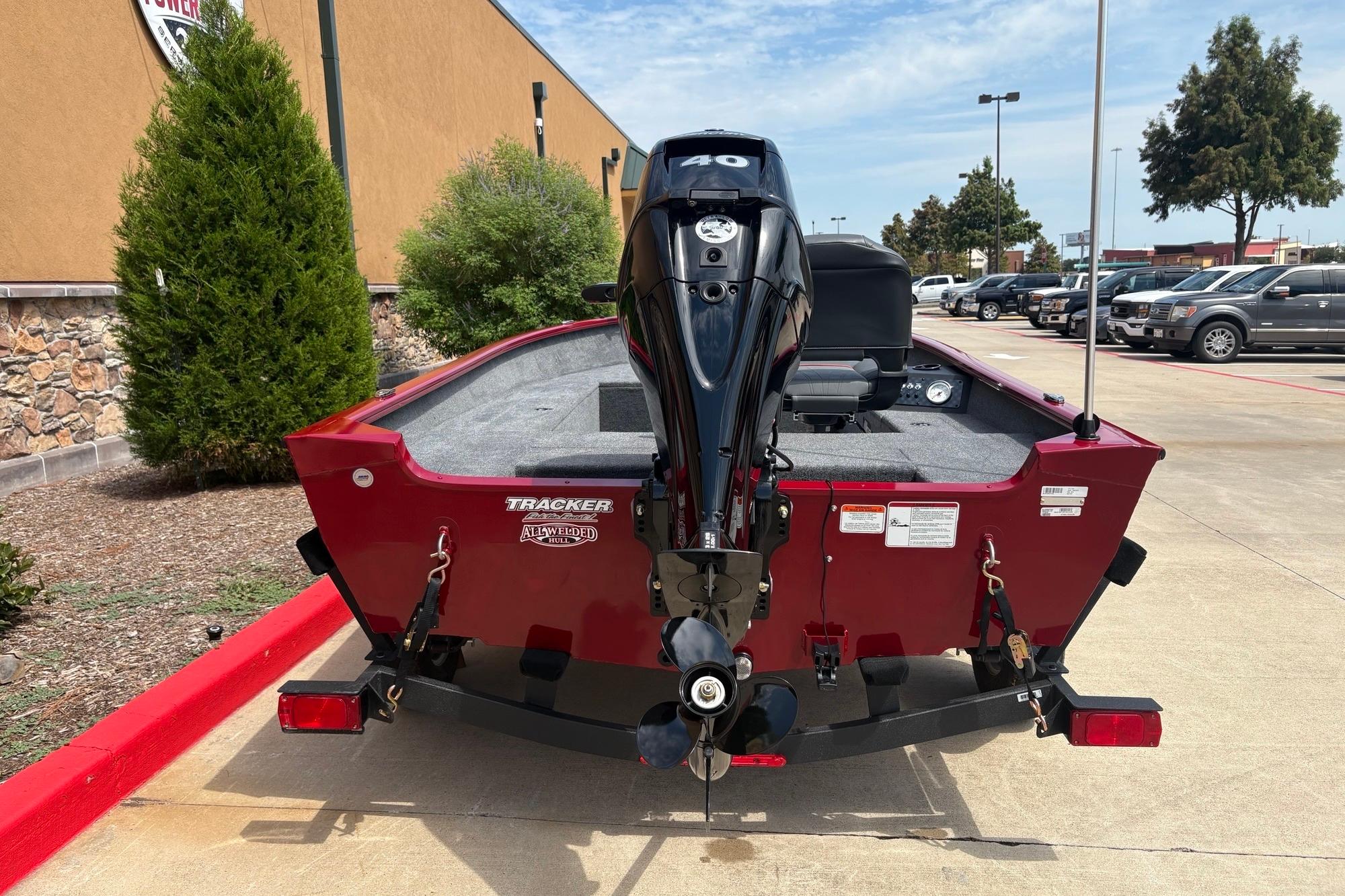 2026 Tracker Super Guide V-16 T boat with outboard motor, parked outdoors.